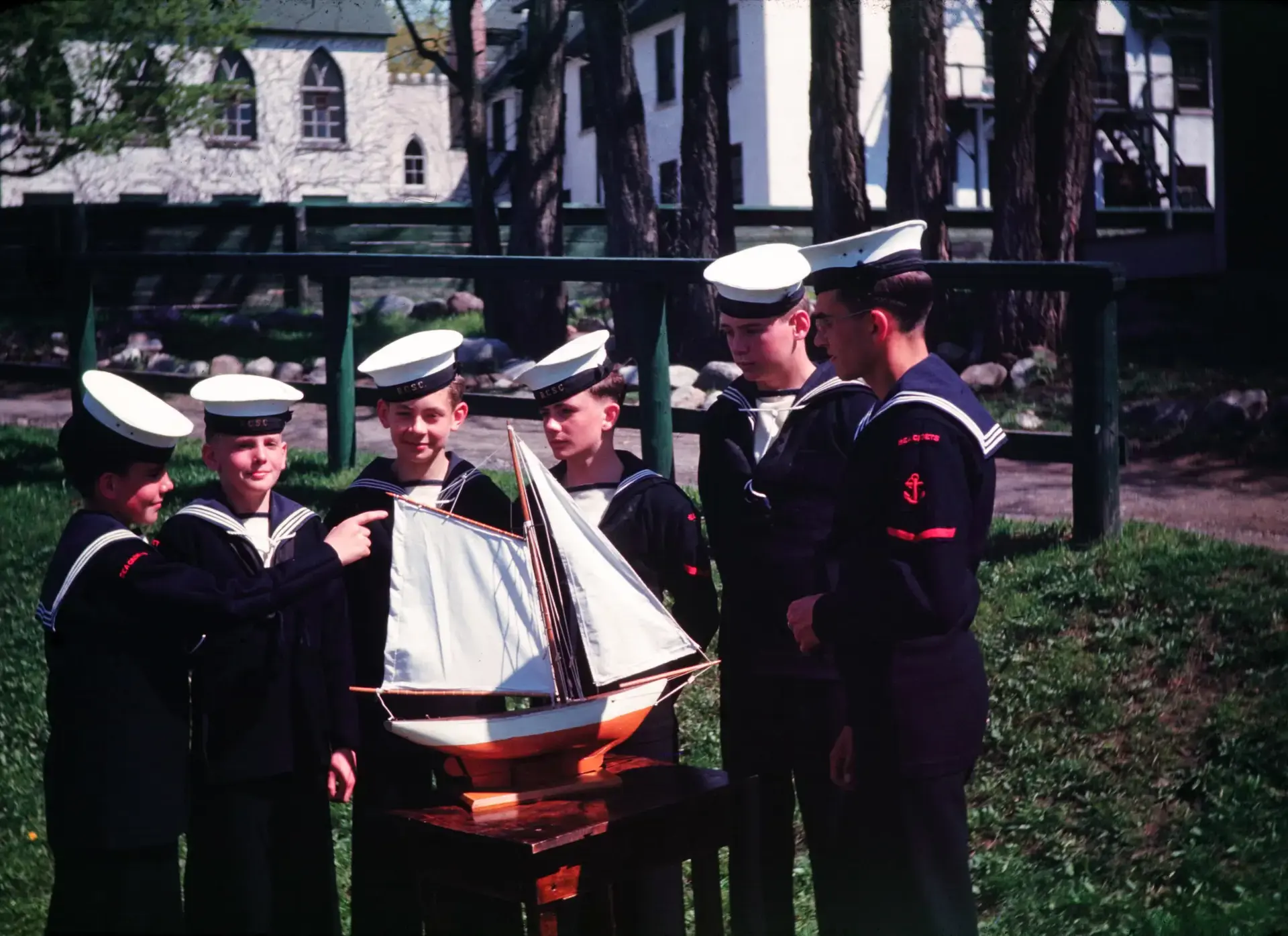 Lakefield students in naval uniforms holding model boats