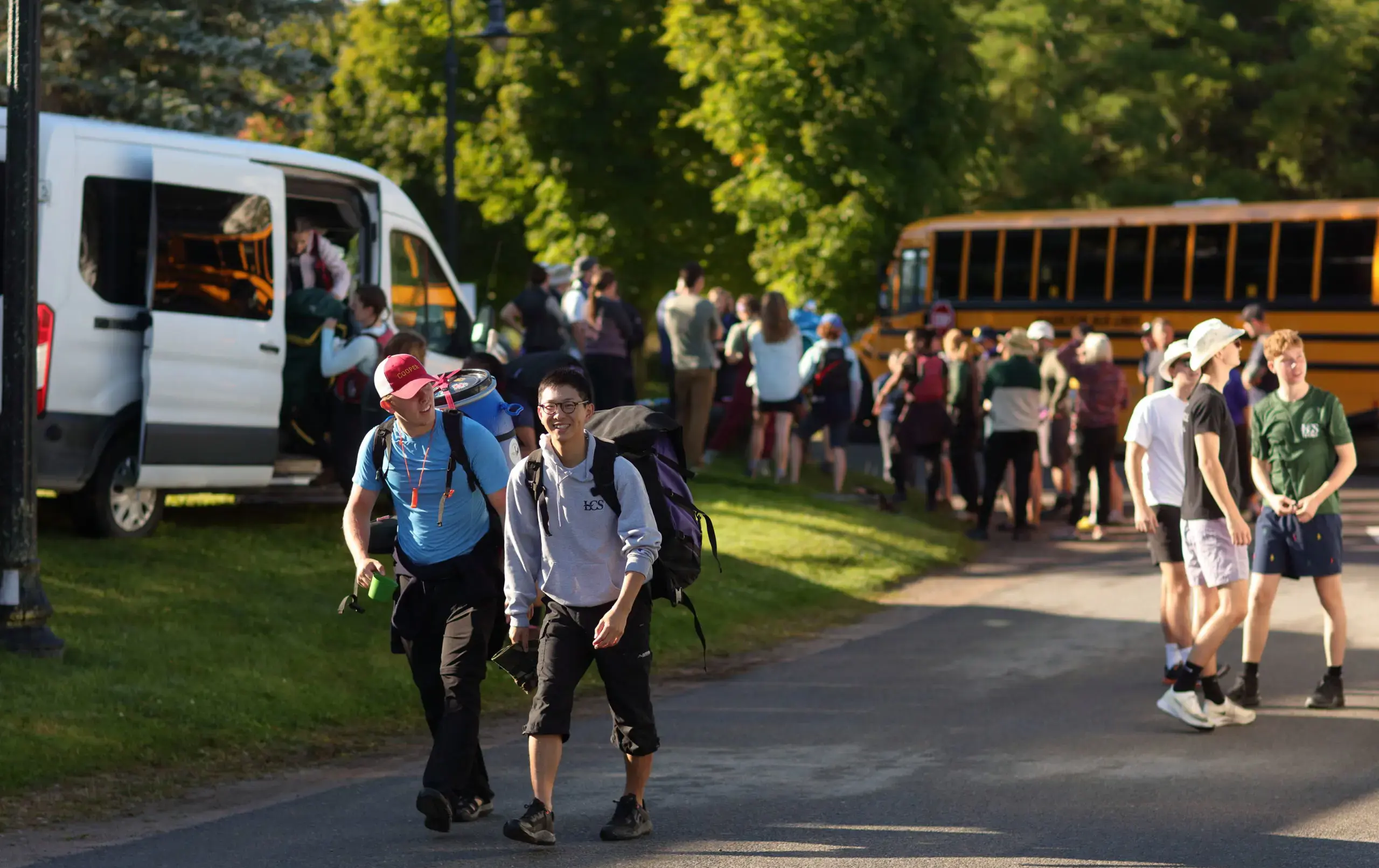 Students disembarking from school bus on sunny day