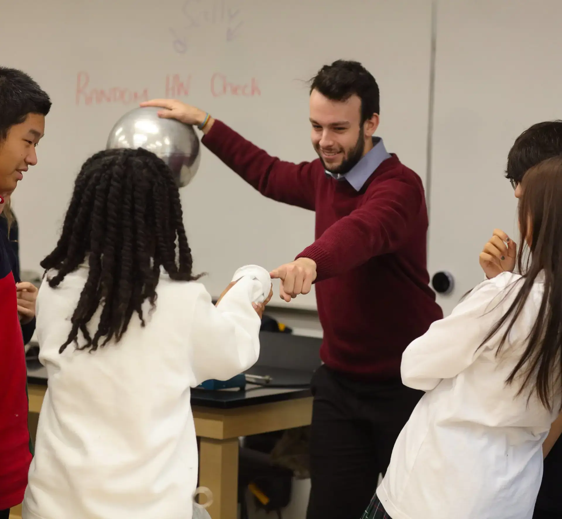 Teacher using Van de Graaff generator in demonstration to students