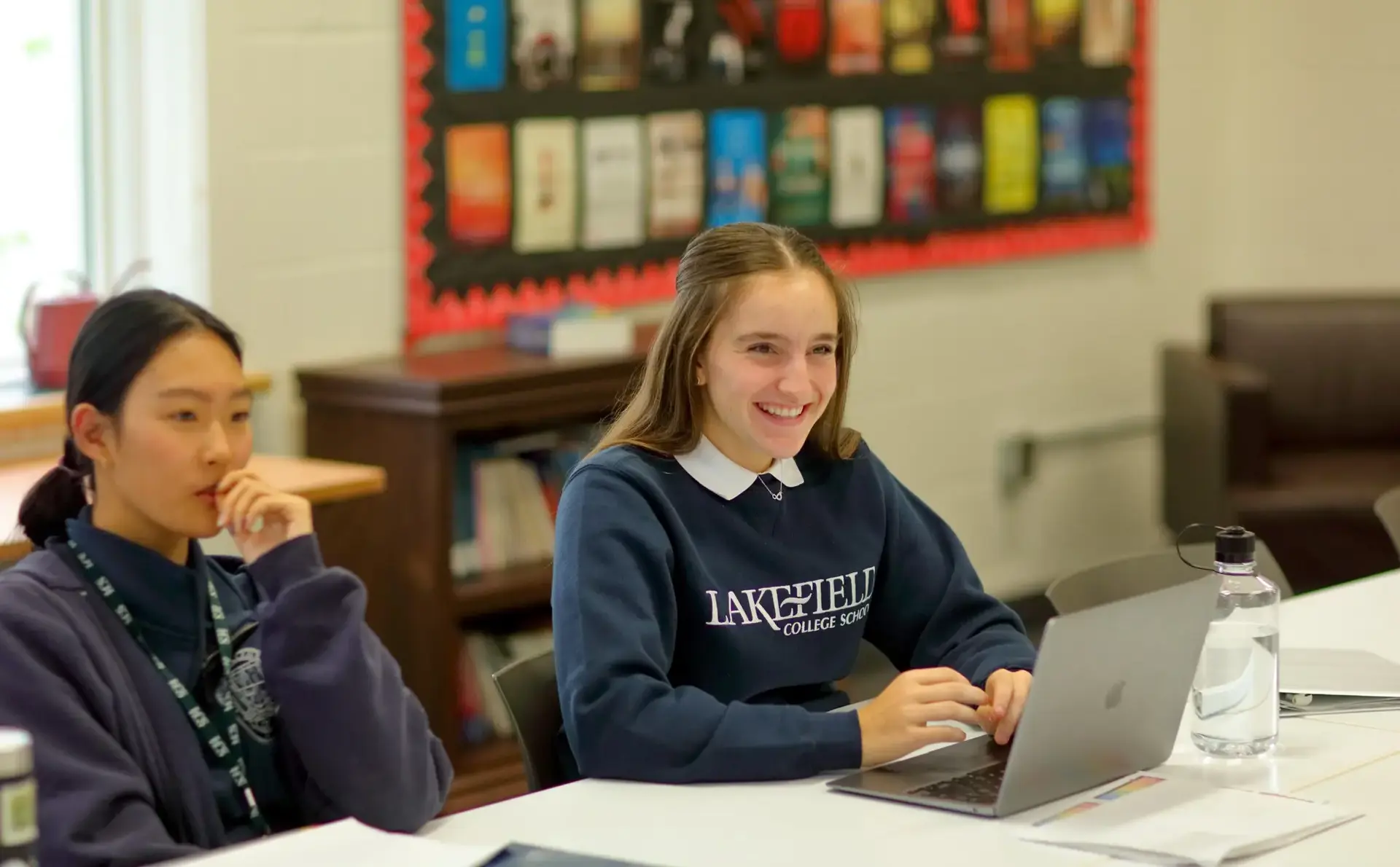 Student smiling up from laptop