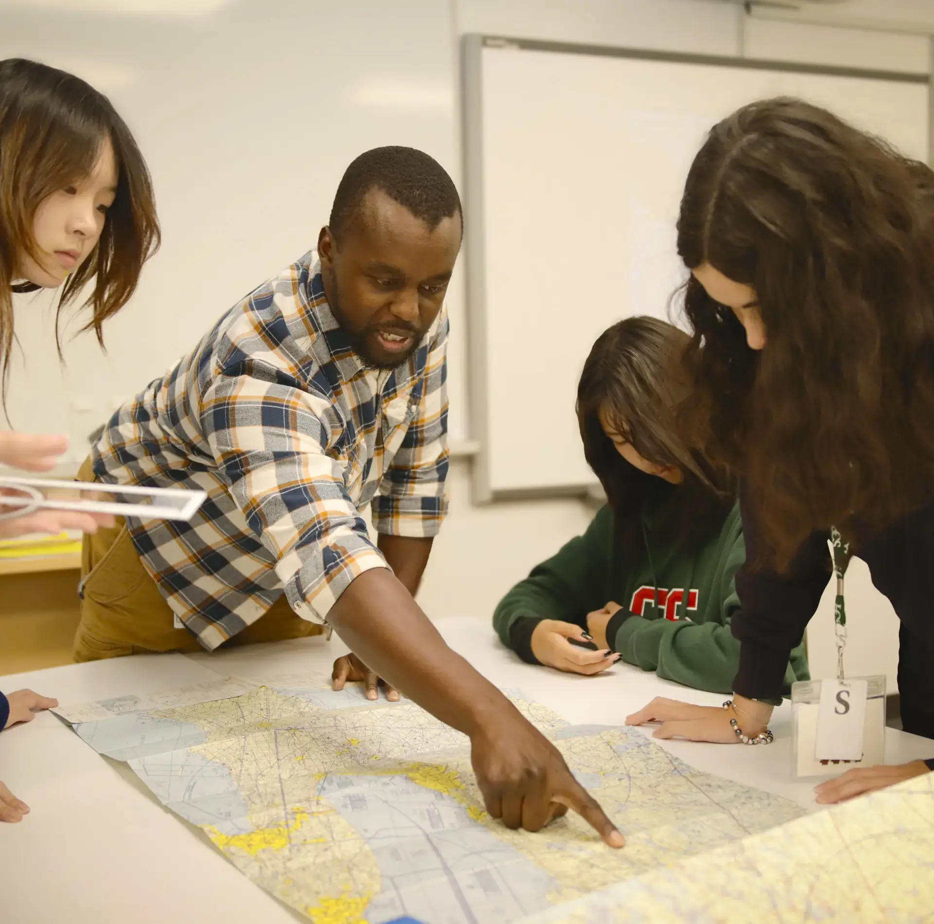 Students and teacher in aviation club pointing at diagram