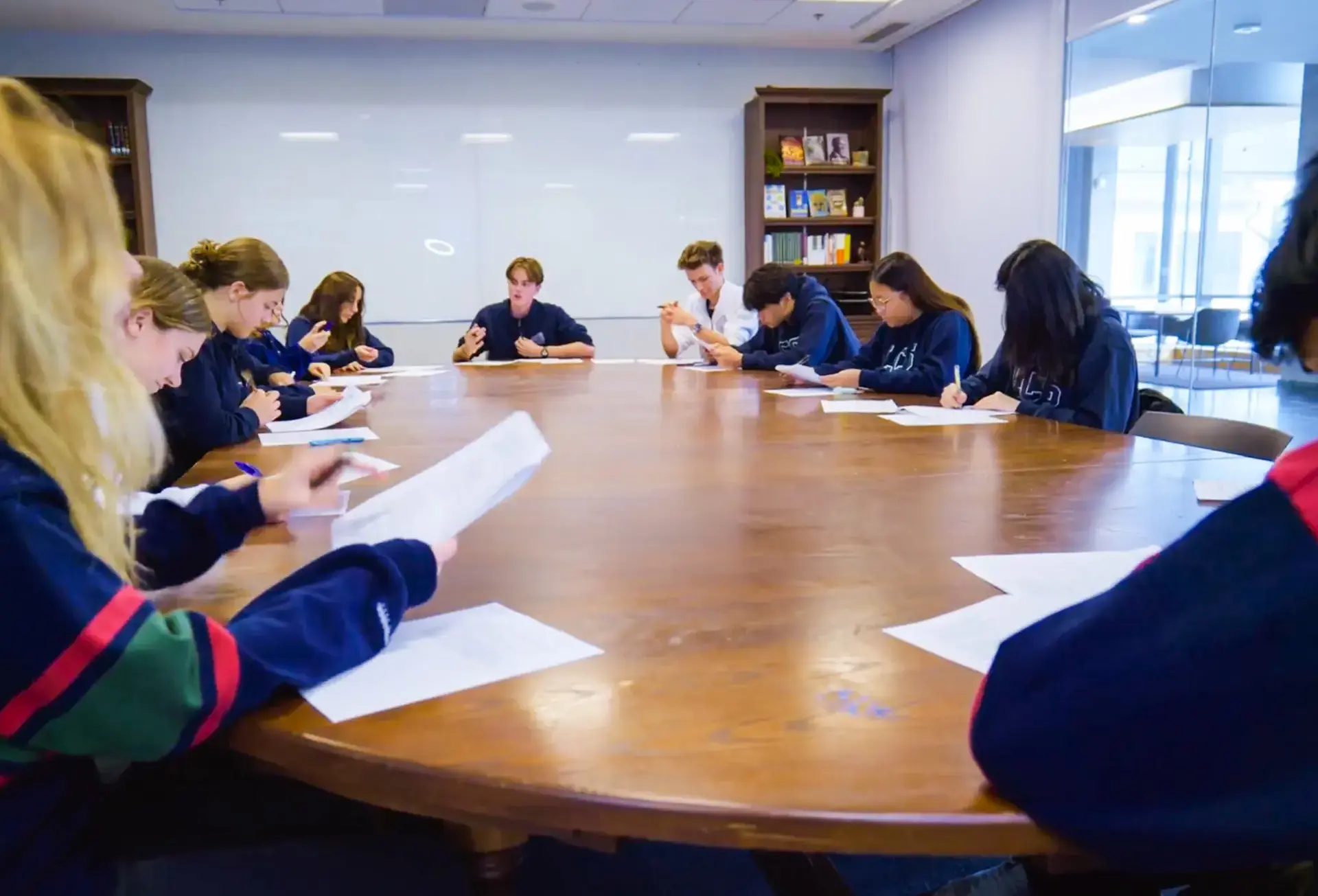 Students examining papers on large table