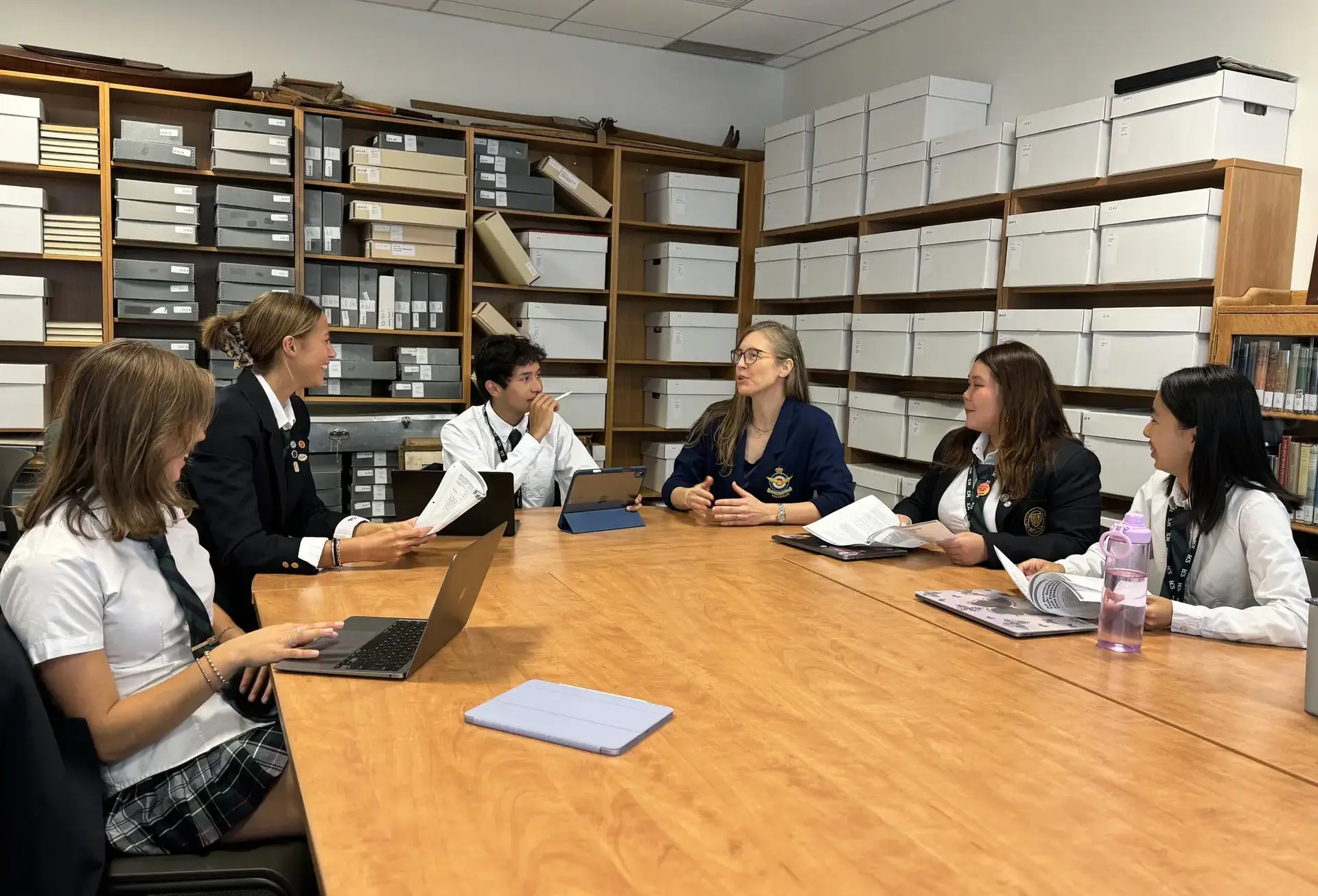 Students chatting around table in archive room