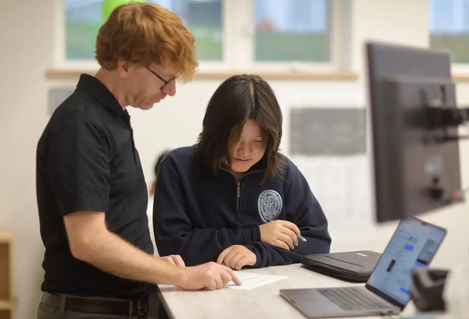 Two students looking down at sheet of paper