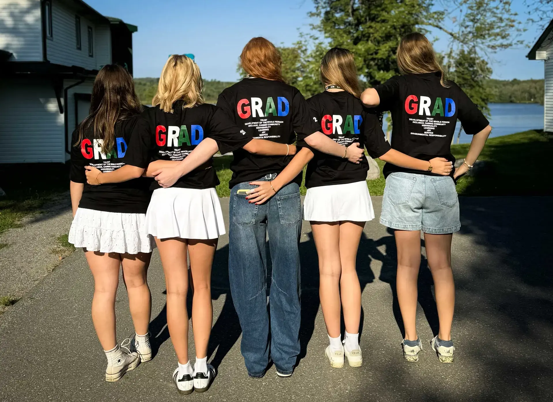 Students arm-in-arm, wearing 'grad' t-shirts