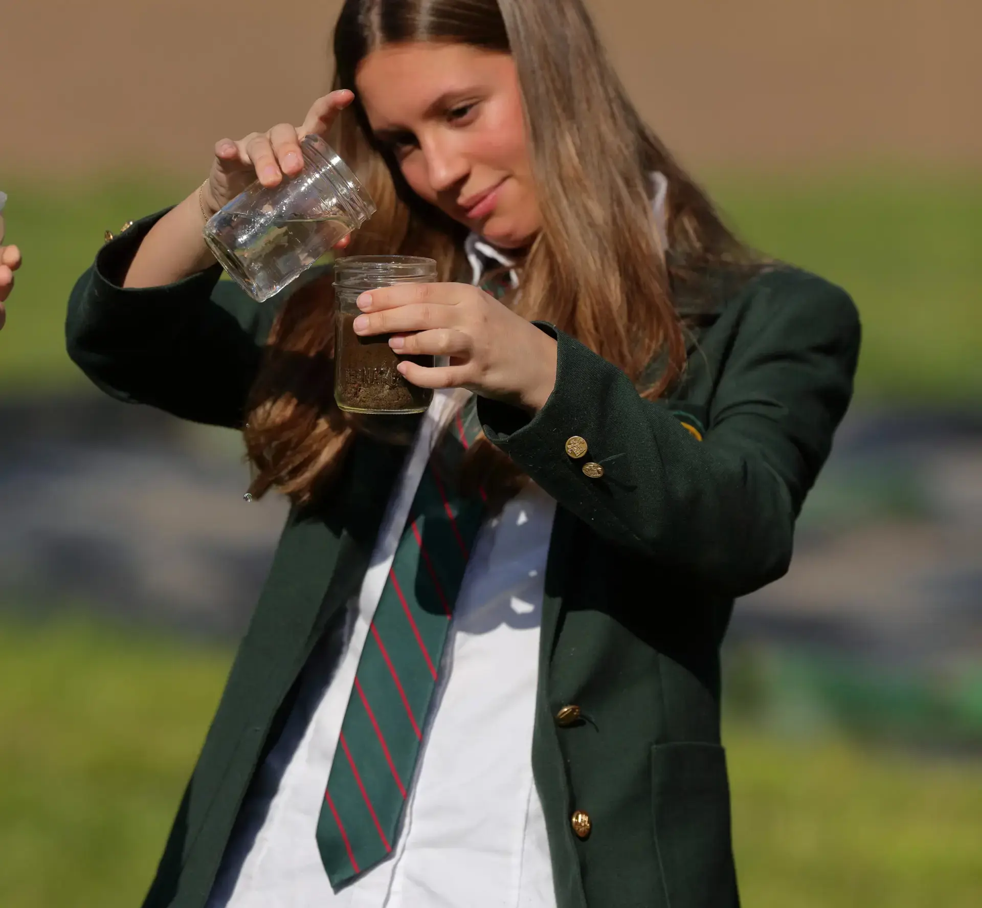 Student pouring soil sample into beaker