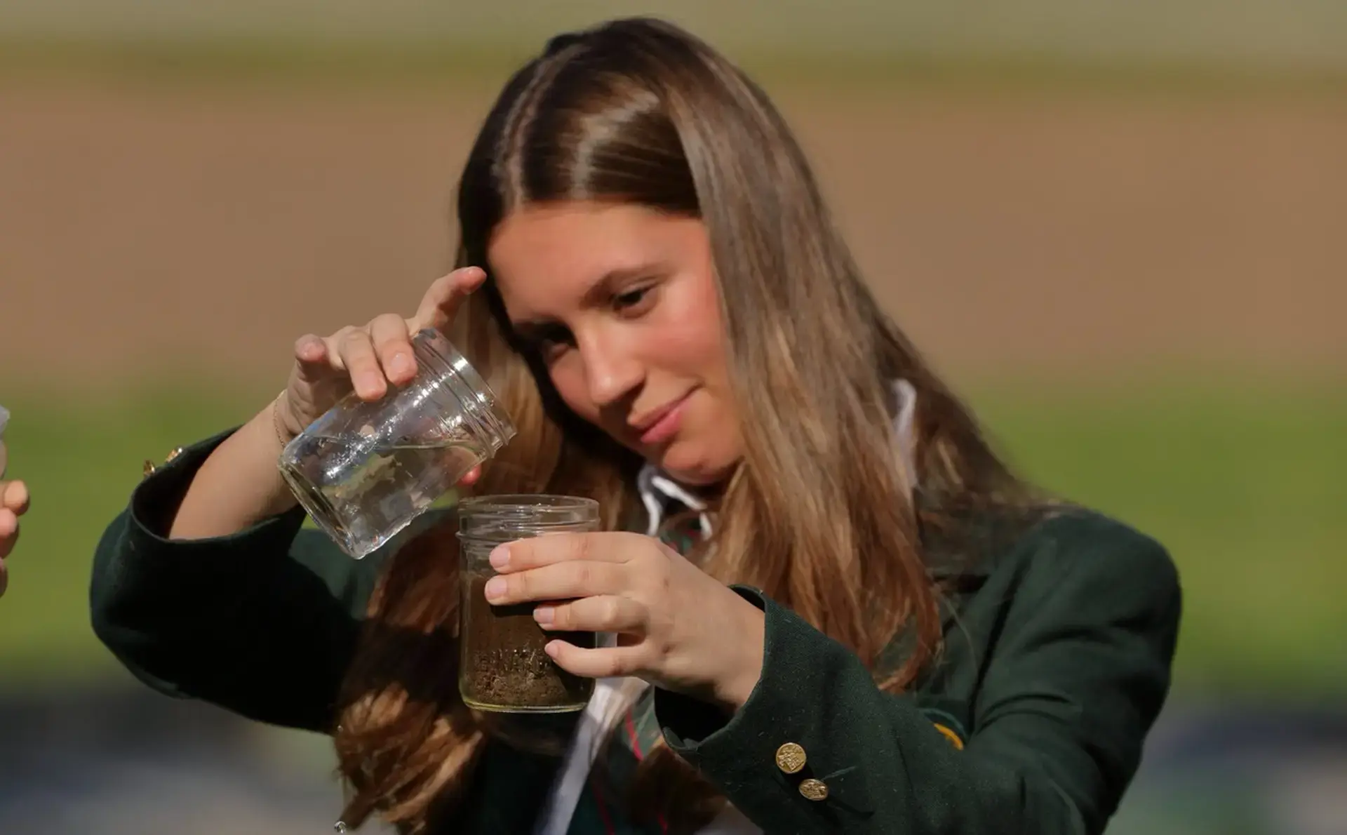 Student looking at soil sample during an outdoor learning session