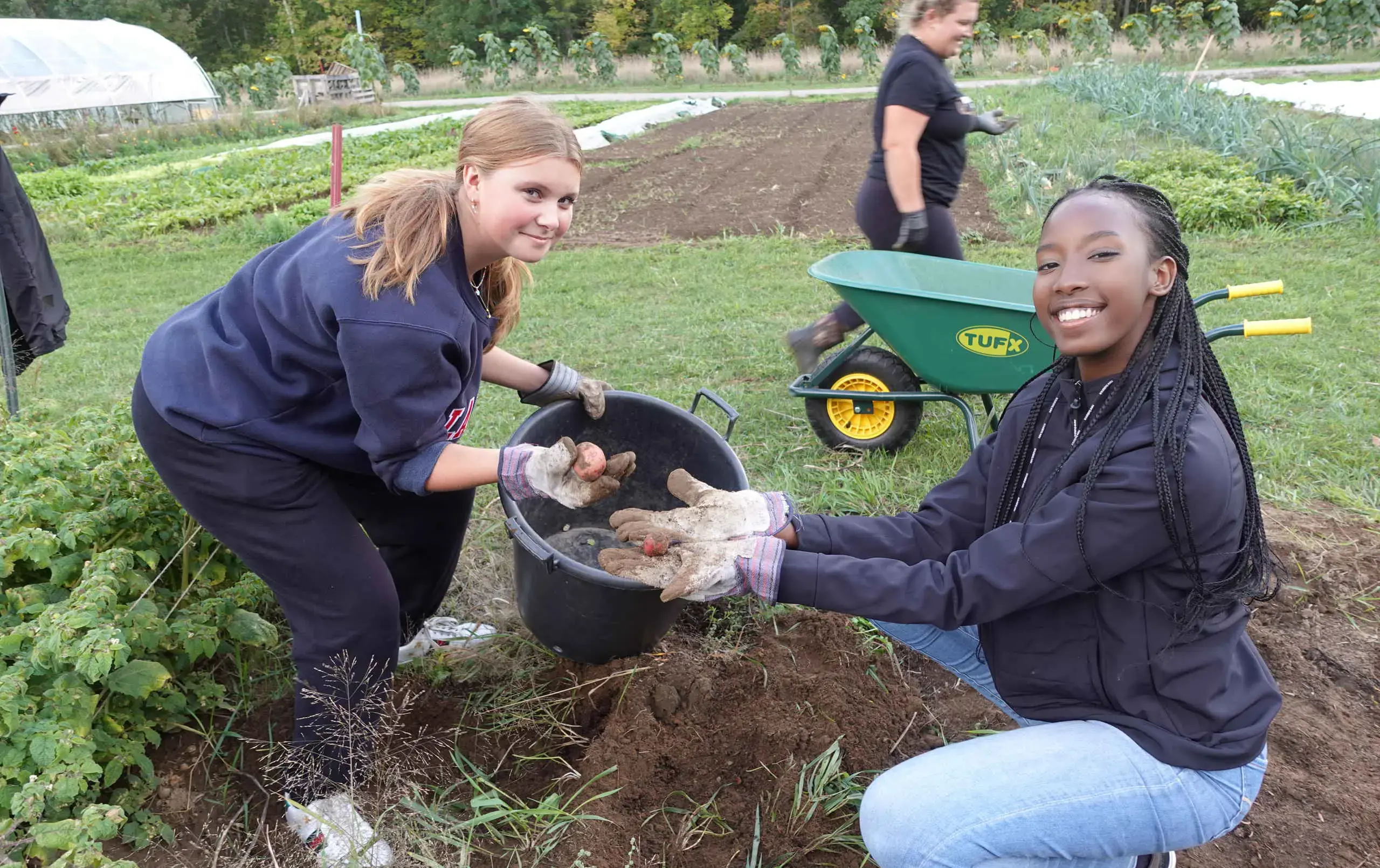 Studets presenting harvested vegetables to camera