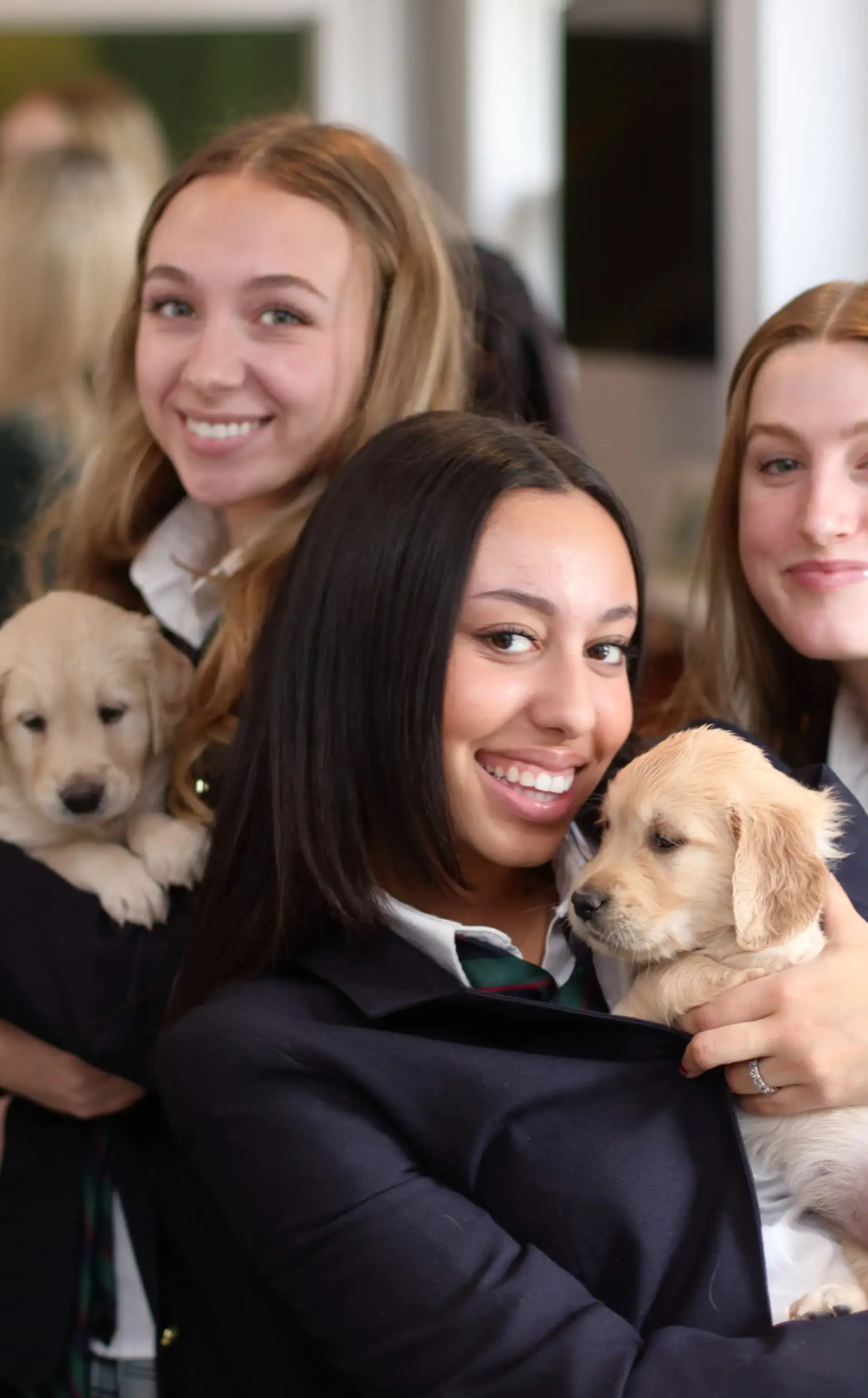 Smiling students holding puppies