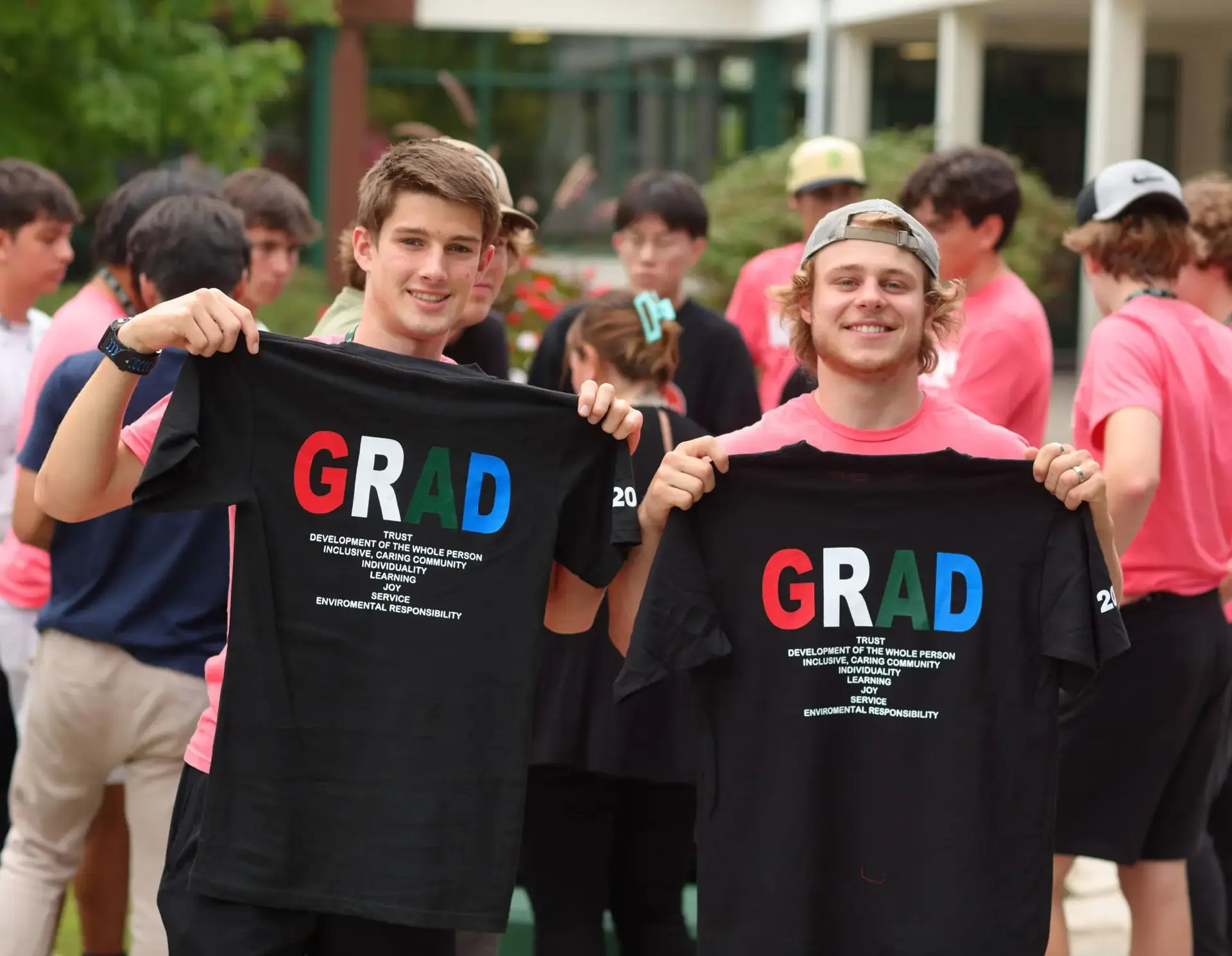Students holding 'grad' t-shirts