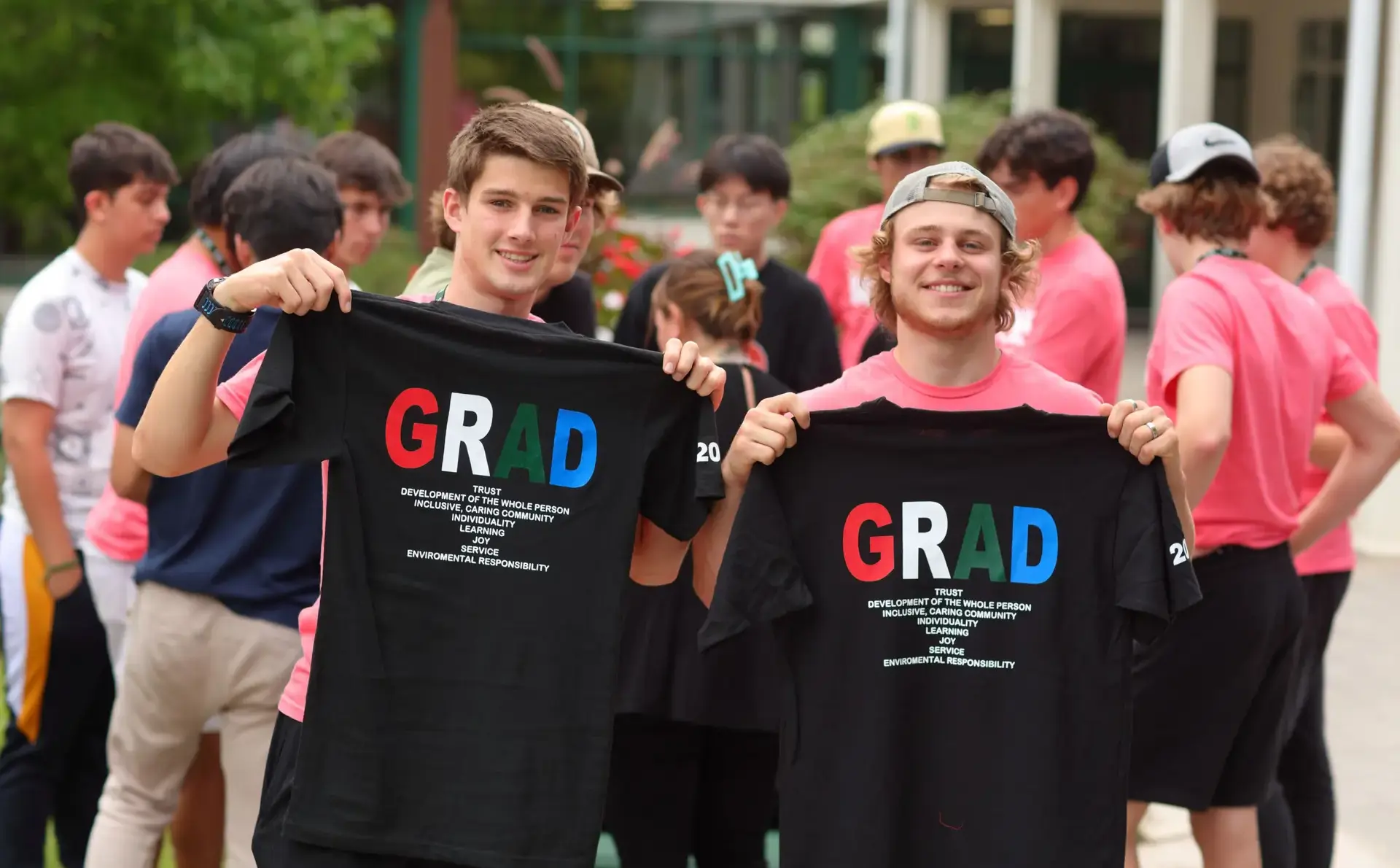 Students holding 'grad' t-shirts