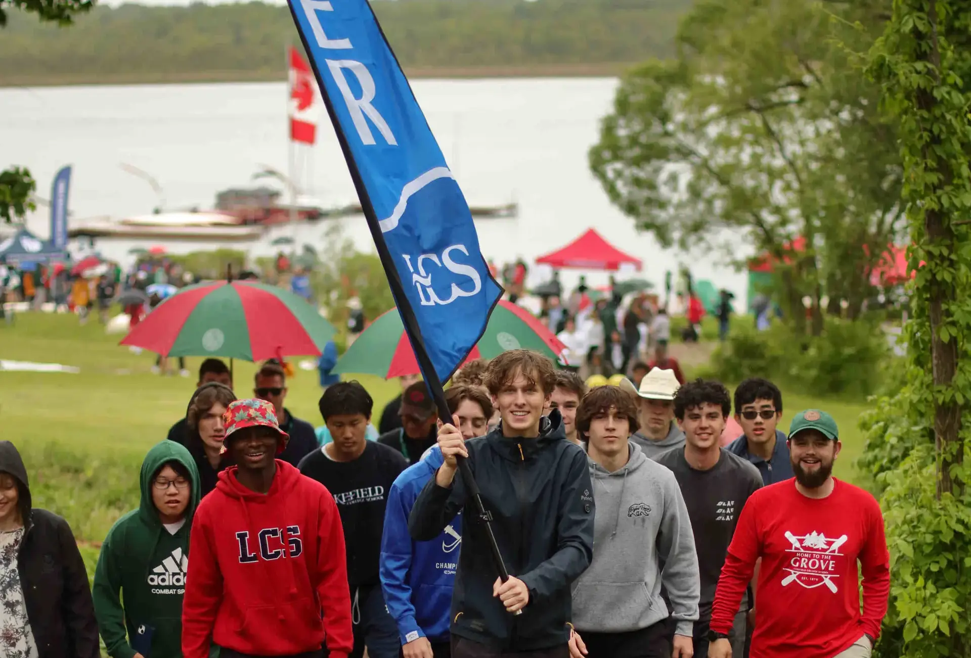 Students walking, carrying flag