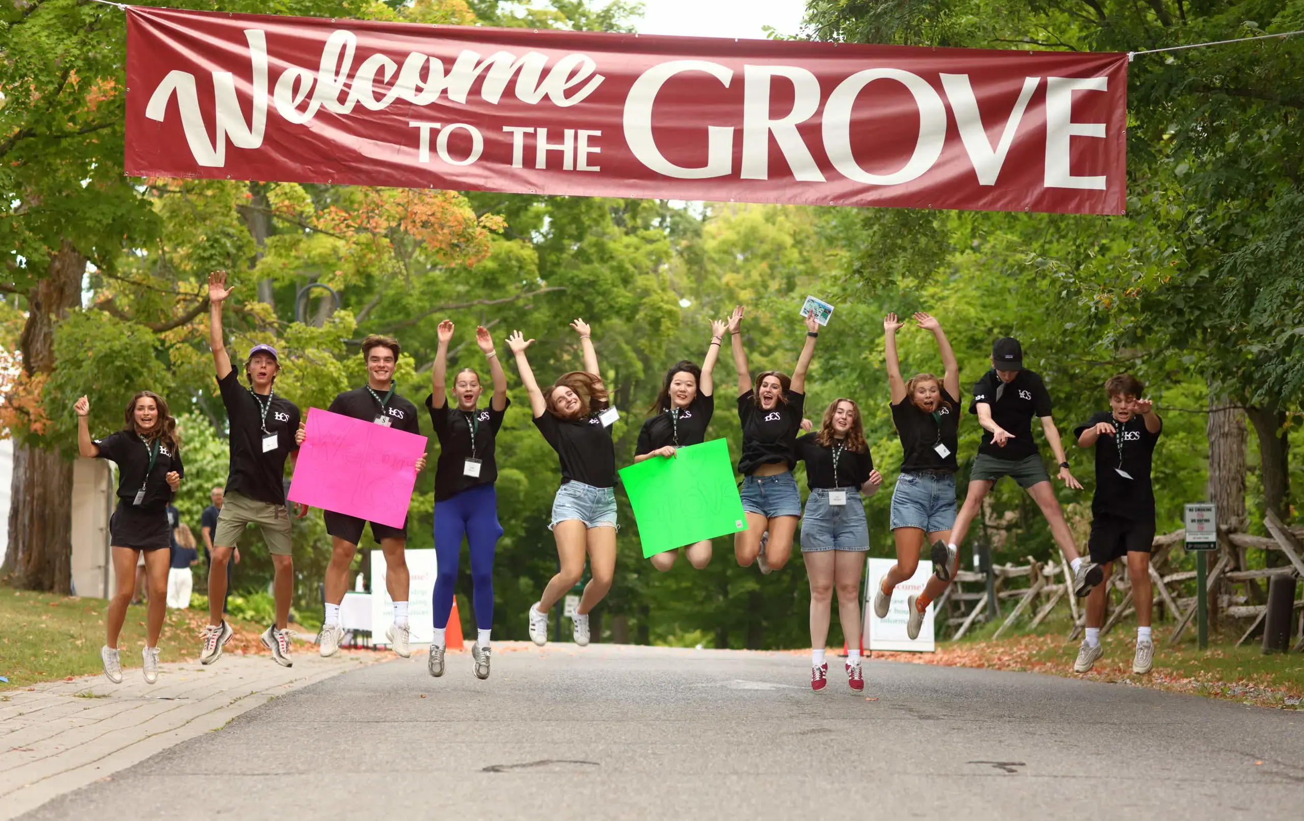 Students jumping in air underneath 'Welcome to Lakefield' banner