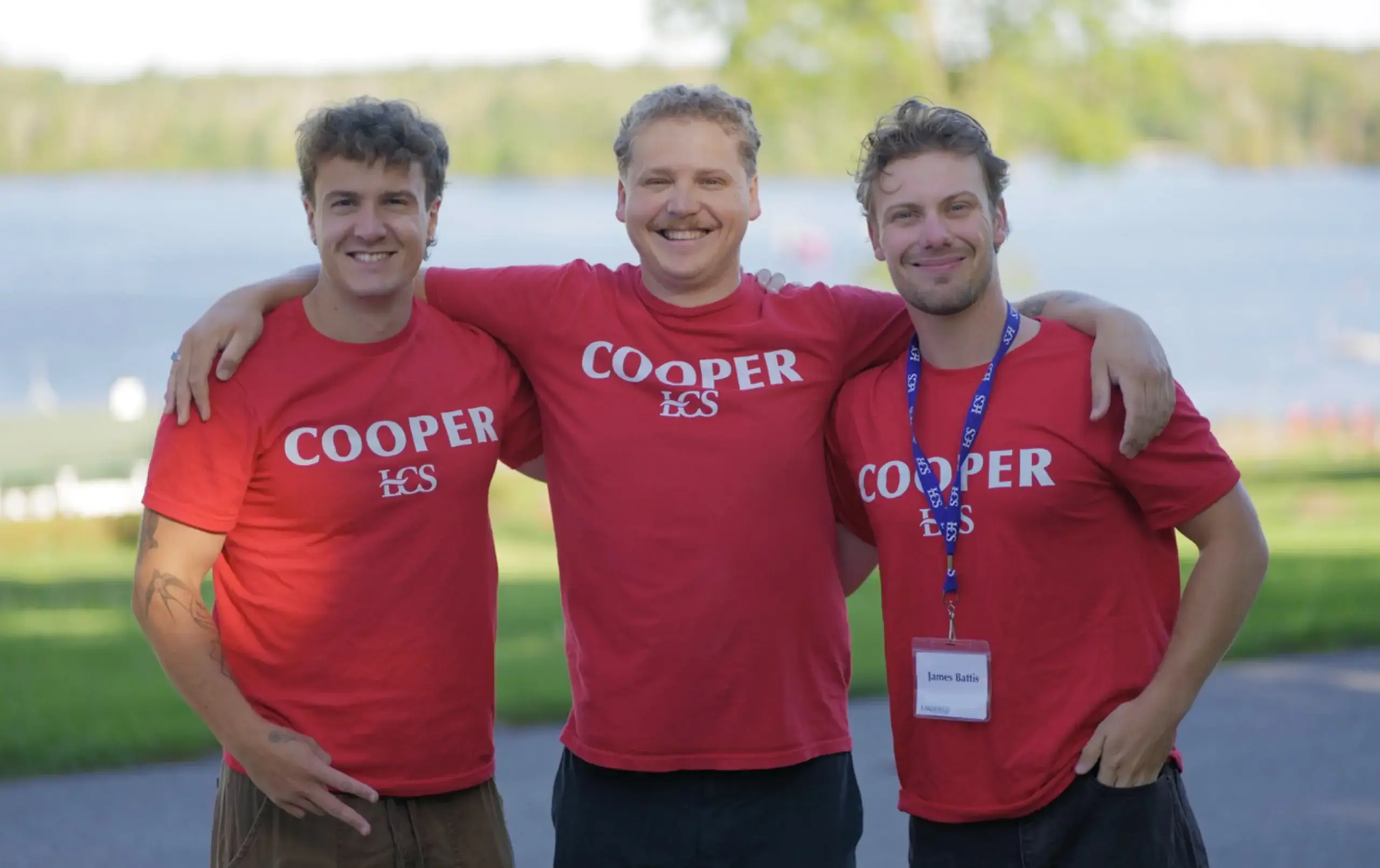 Three Cooper House team members outside at the lake front