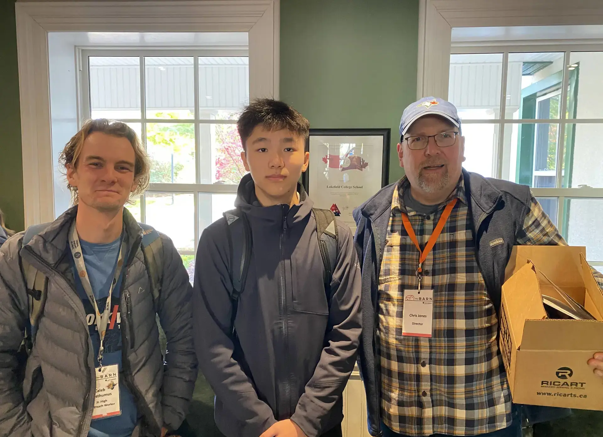 Student standing between two members of staff