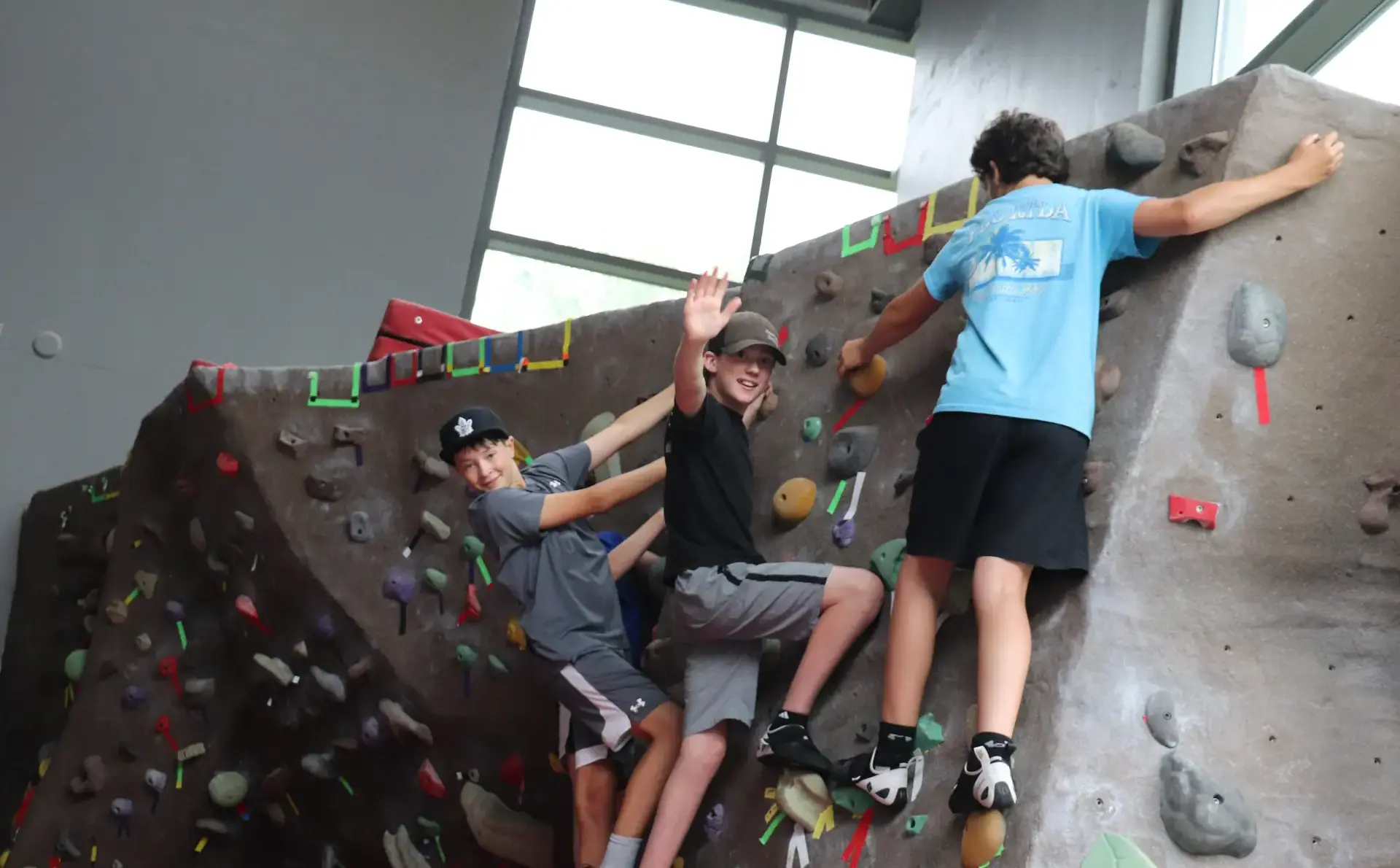 Three campers on the low climb wall at LCS Camps