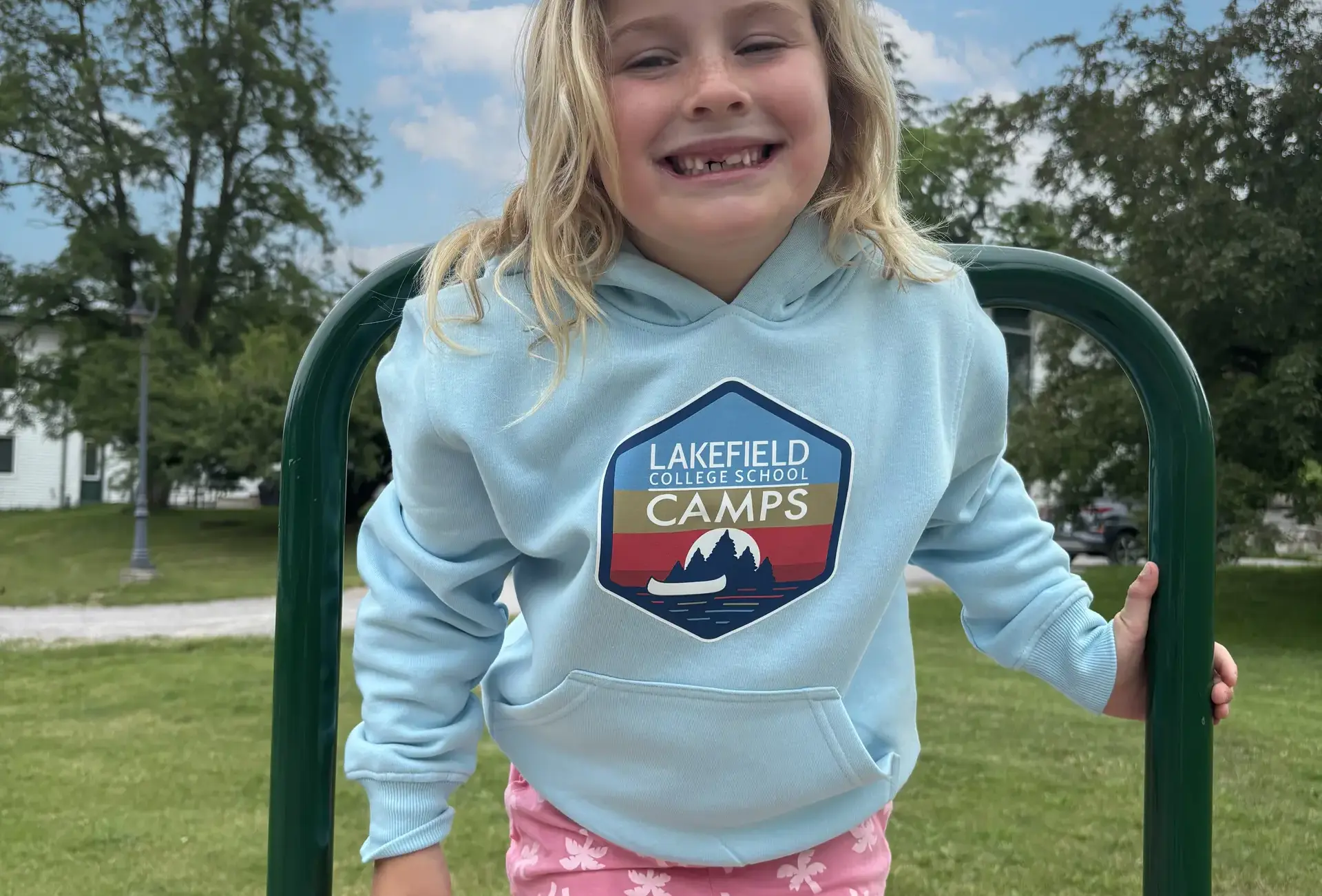 Junior Day camper Audrey modelling the LCS Camps light blue hoodie