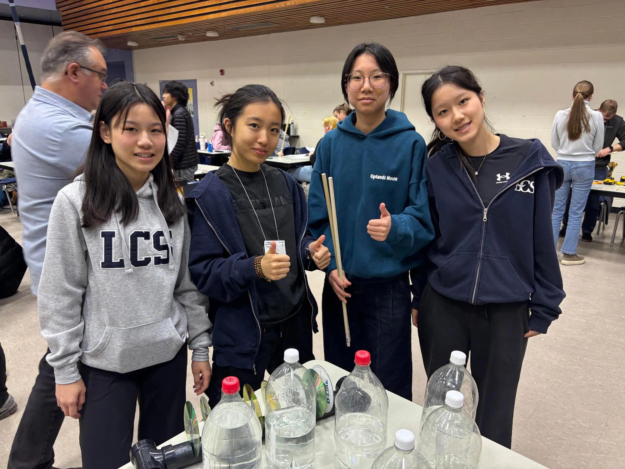 Four students smiling in front of table