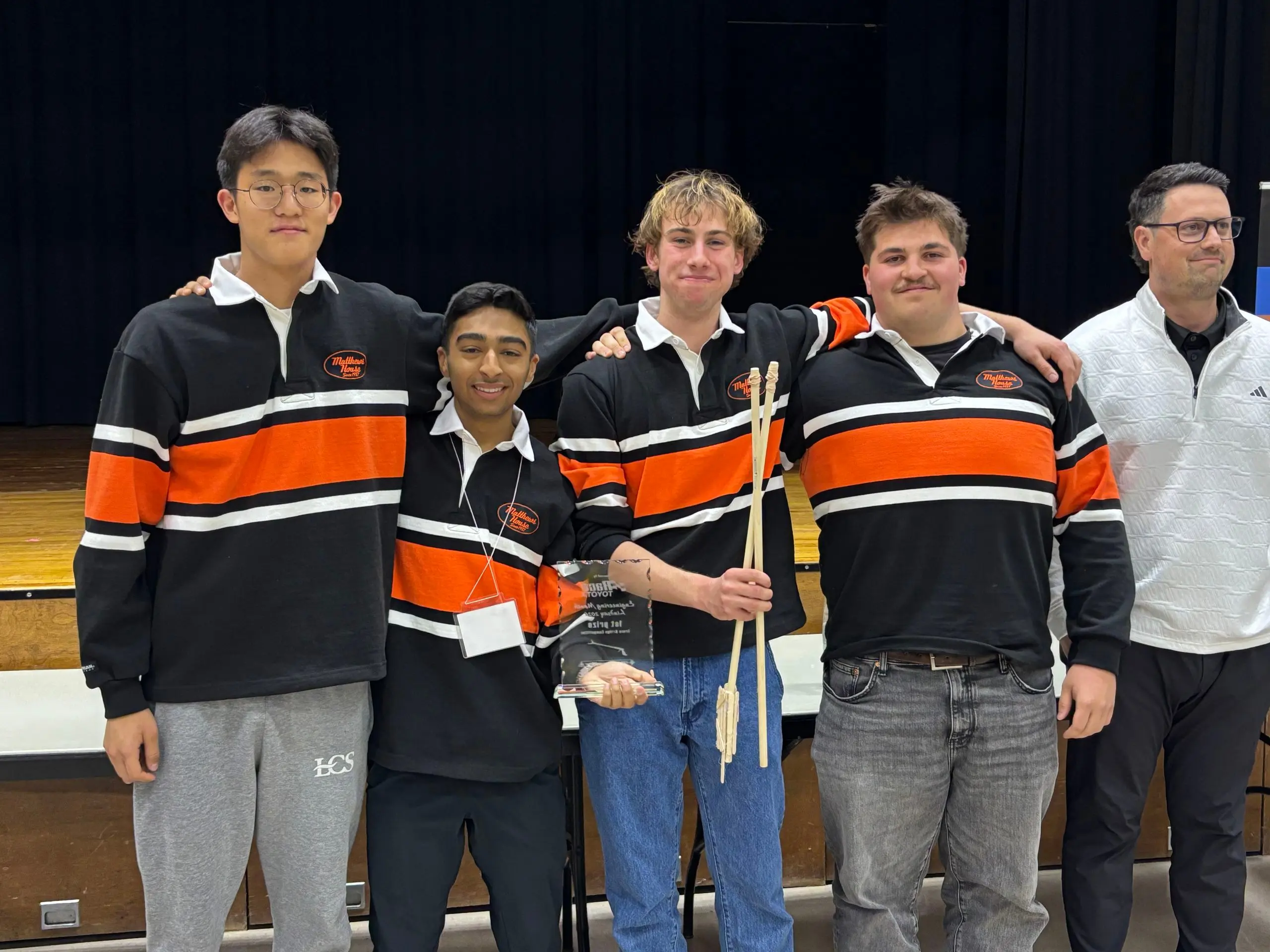 Four students in matching shirts smiling 