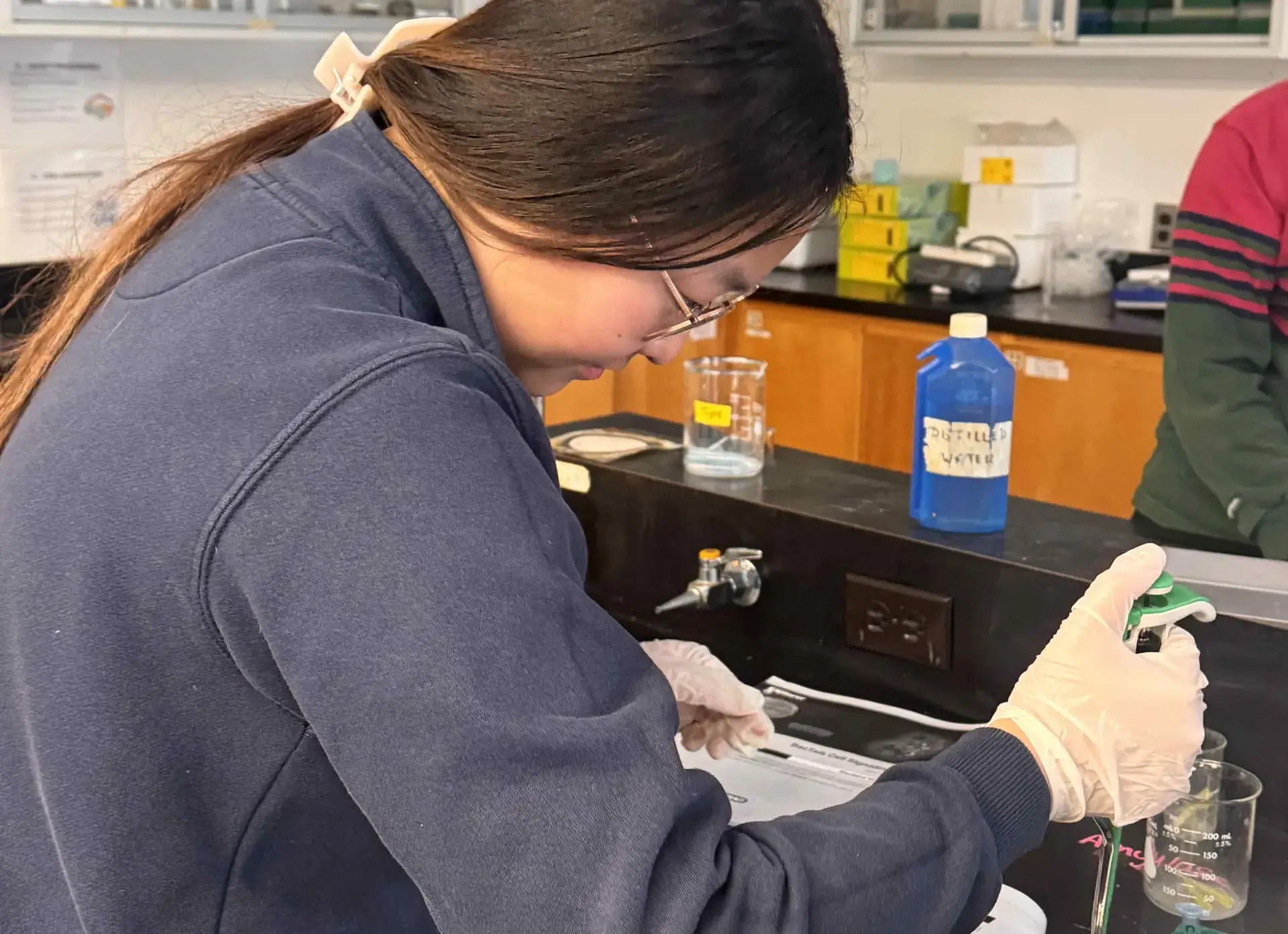 Student holding pipette over petri dish