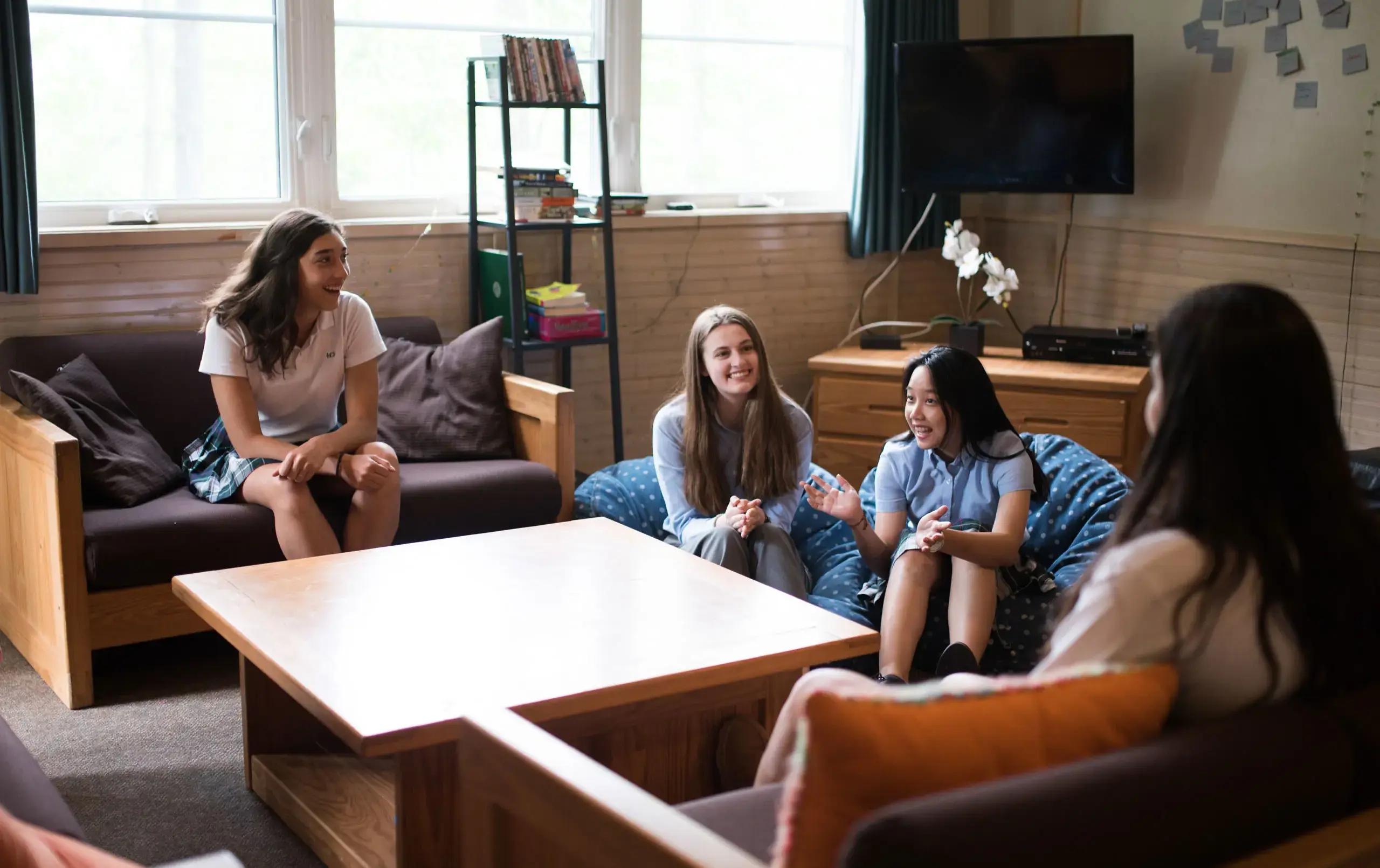Four students hanging out in Moodie House common area