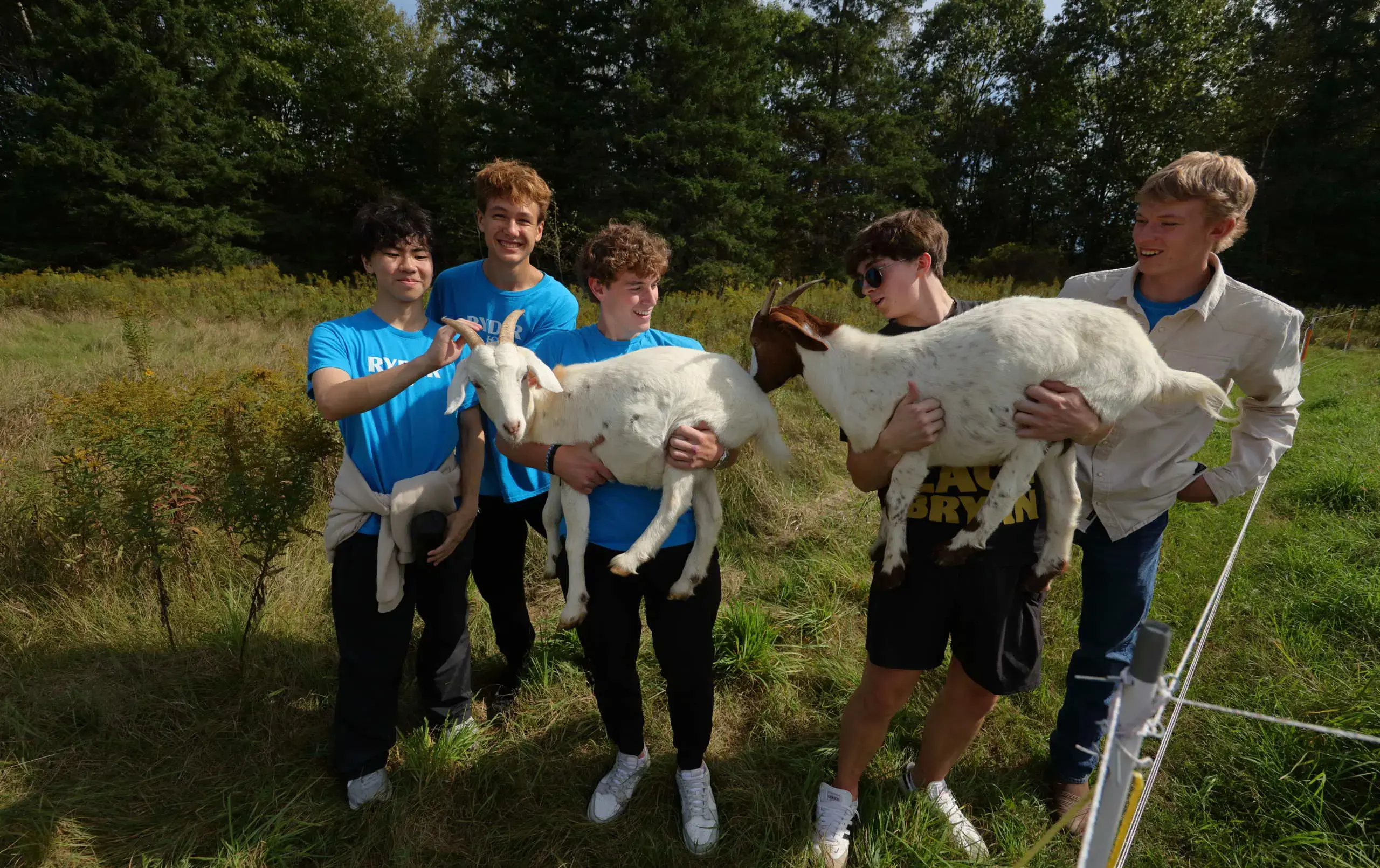 Students holding goats