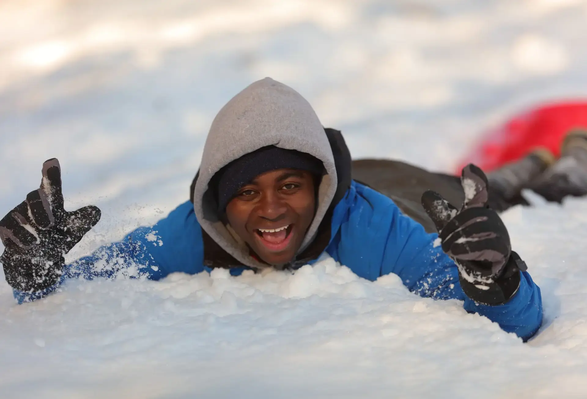 Student lying in the snow, smiling