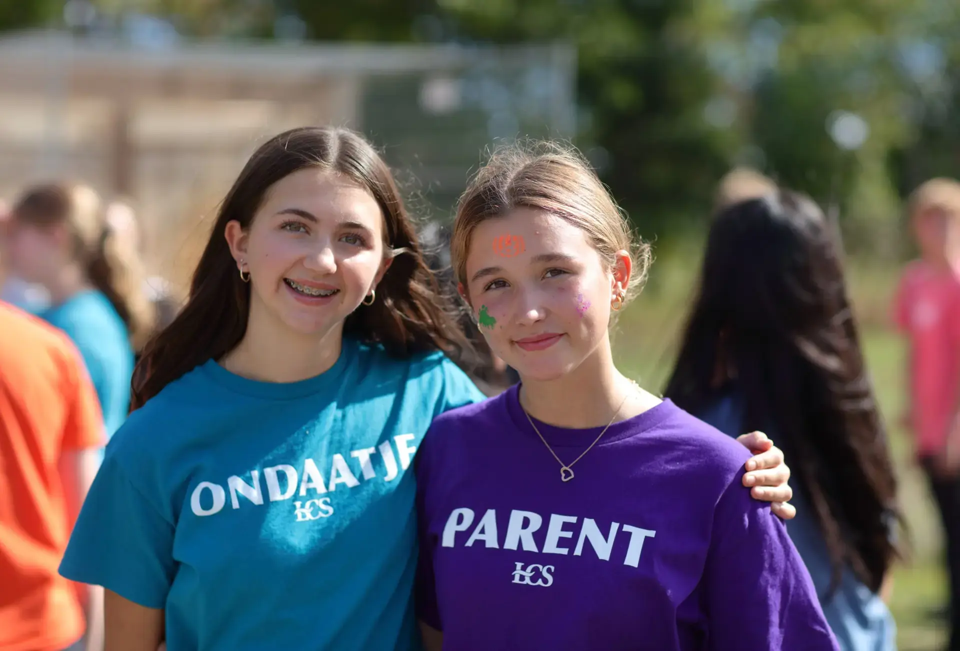 Two students wearing team colours smiling