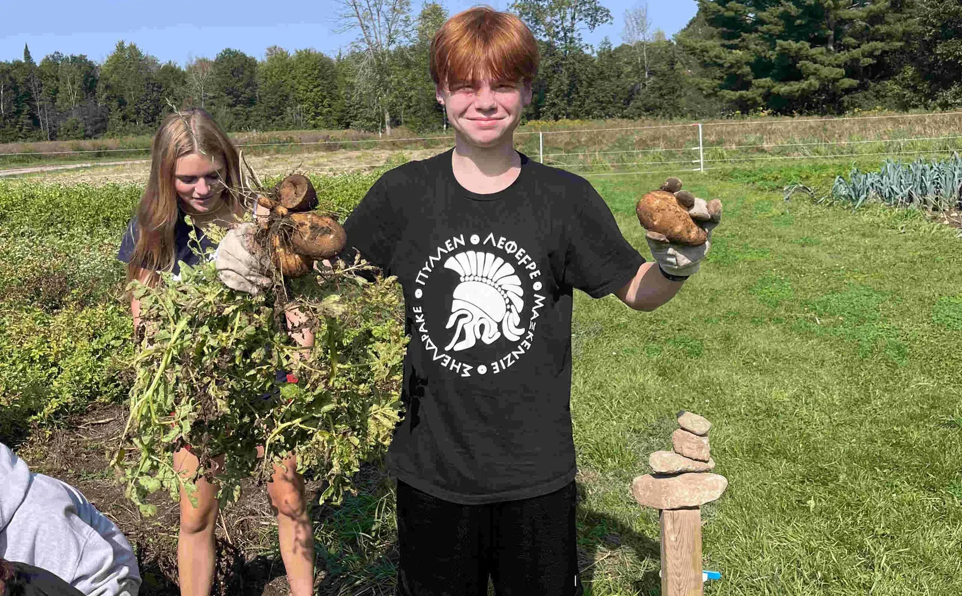 Student holding up harvested potatoes