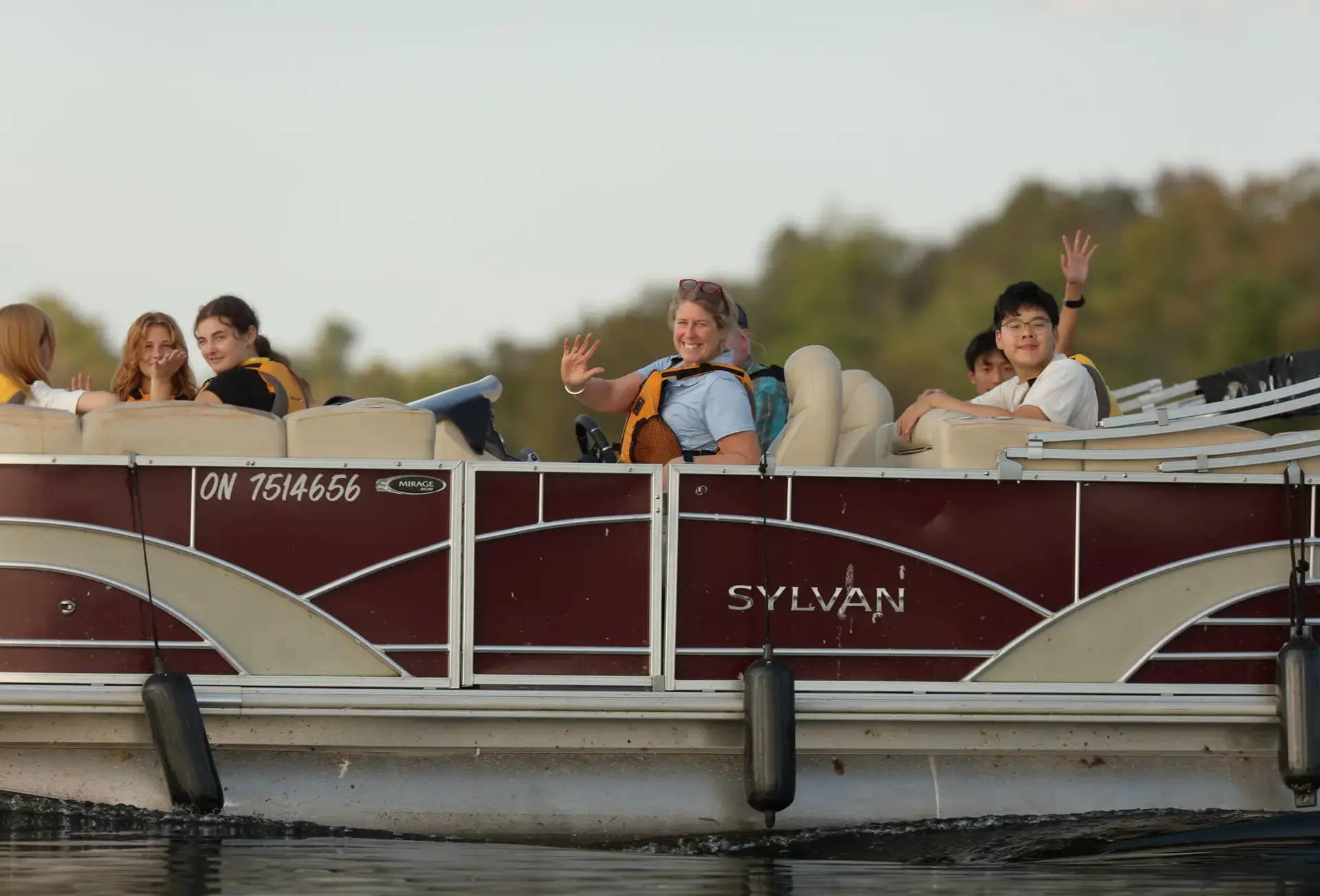 Students waving from boat
