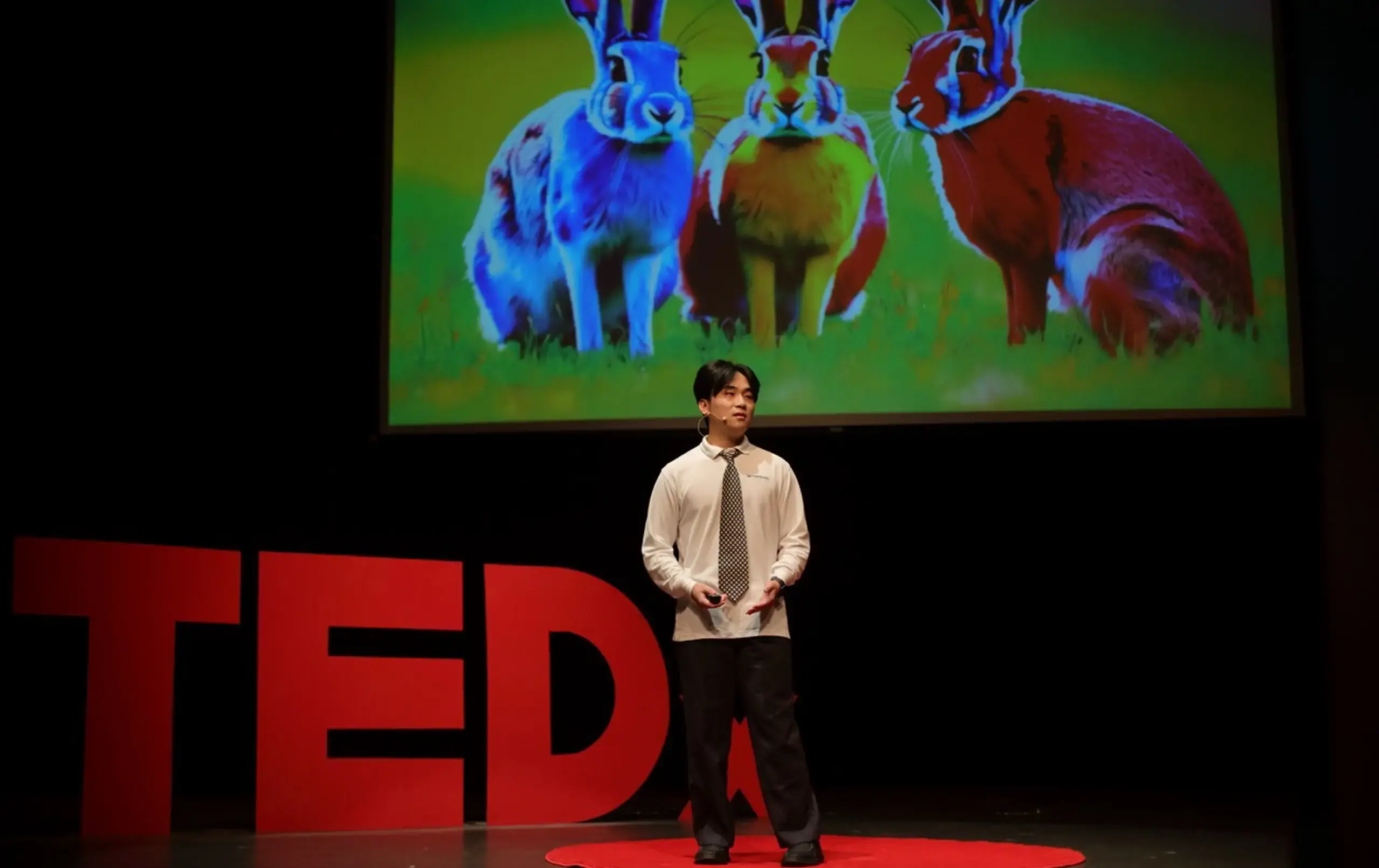 Student presenting on stage during TedEx event