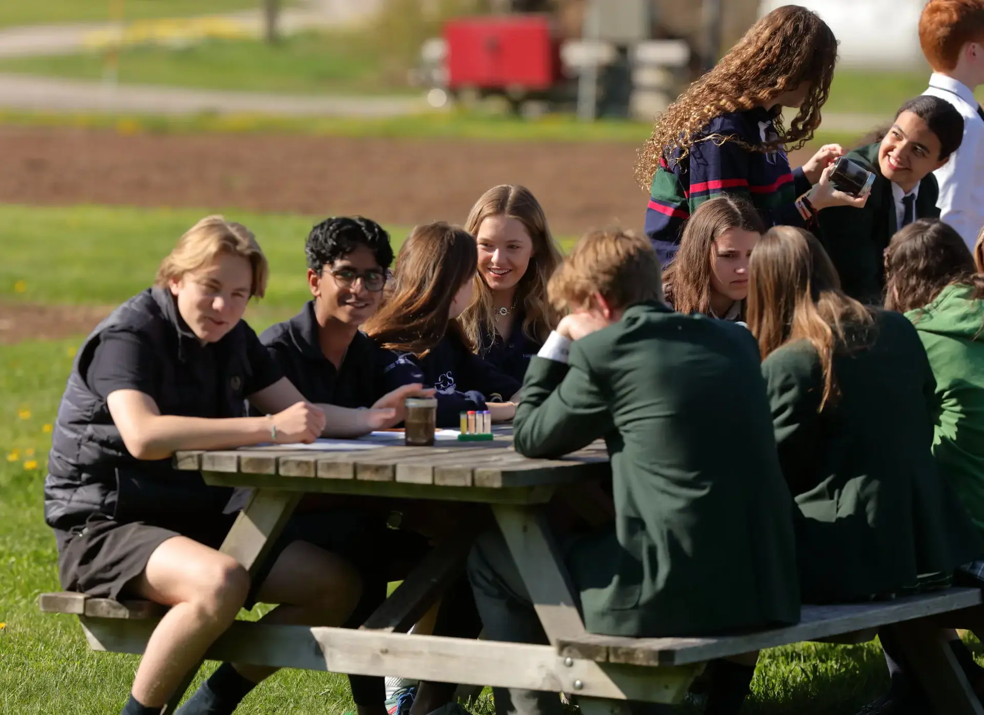 Students sitting around picnic table, chatting