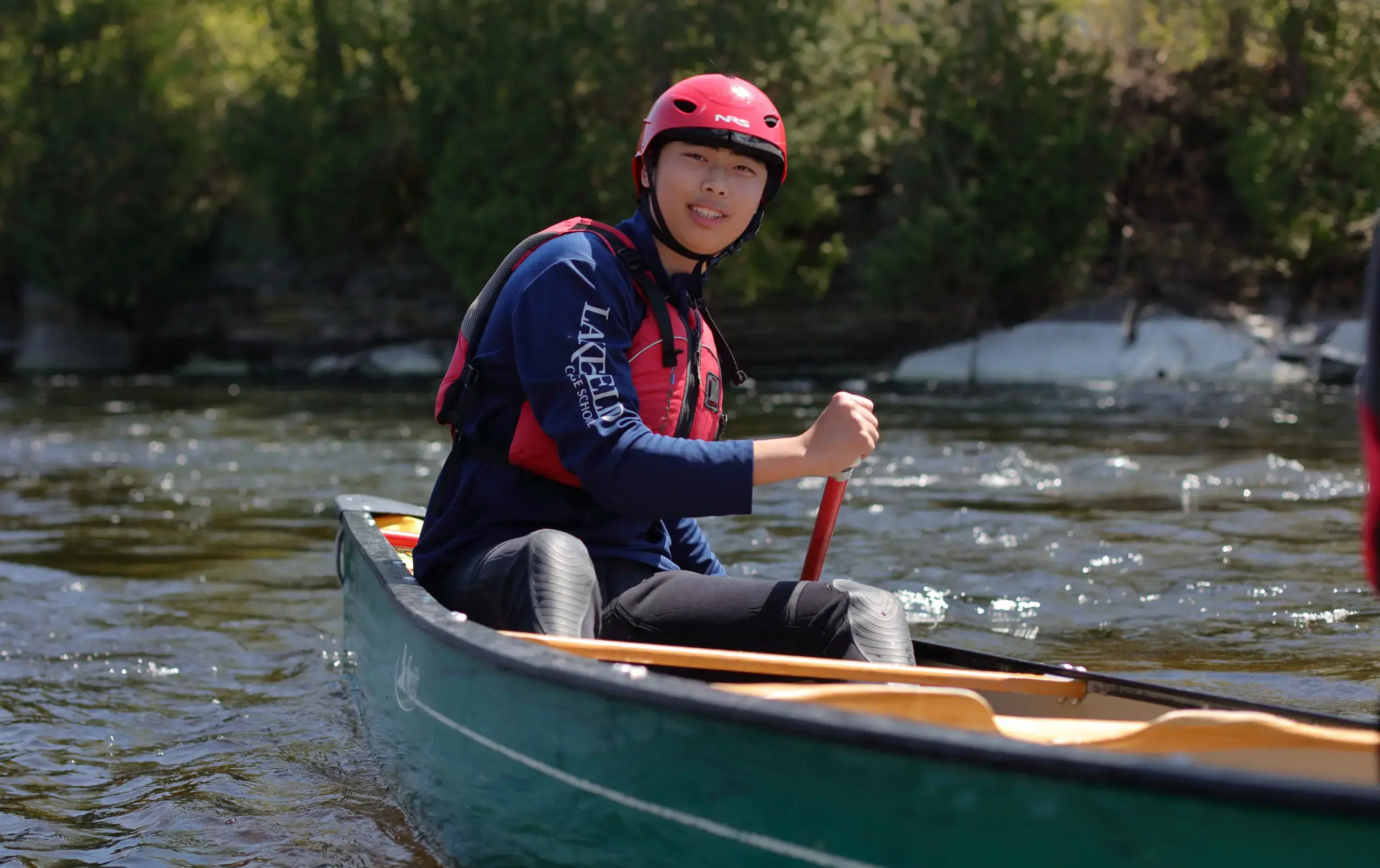 Student canoeing on lake