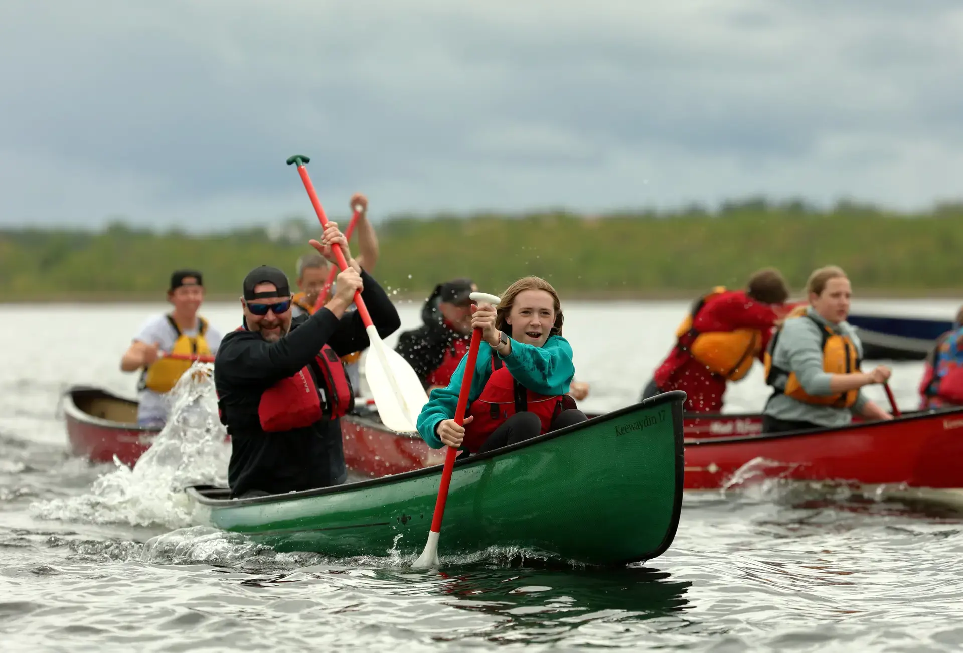 An alumni with a student canoe racing during Regatta Day.