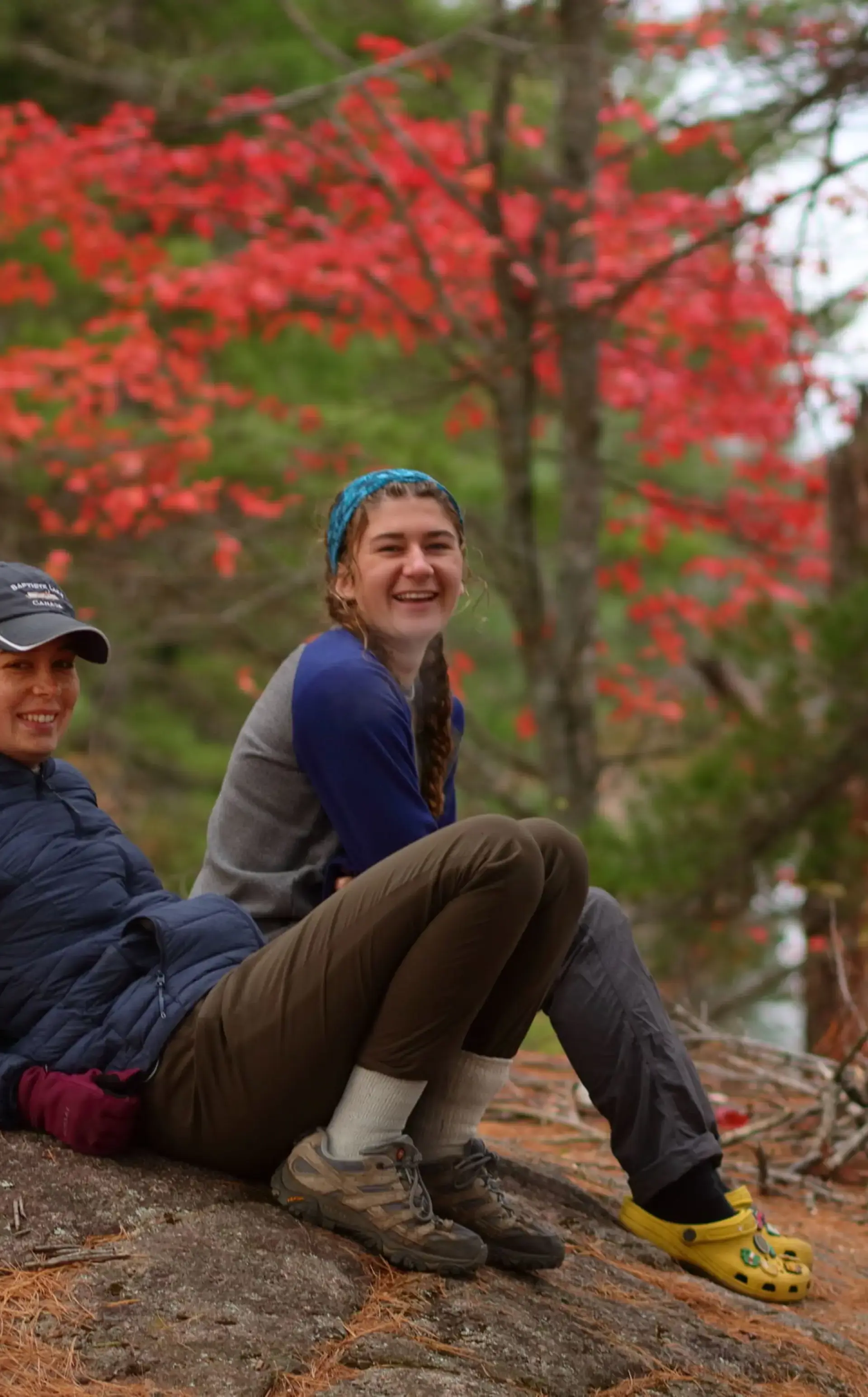 Two students sitting on forest floor