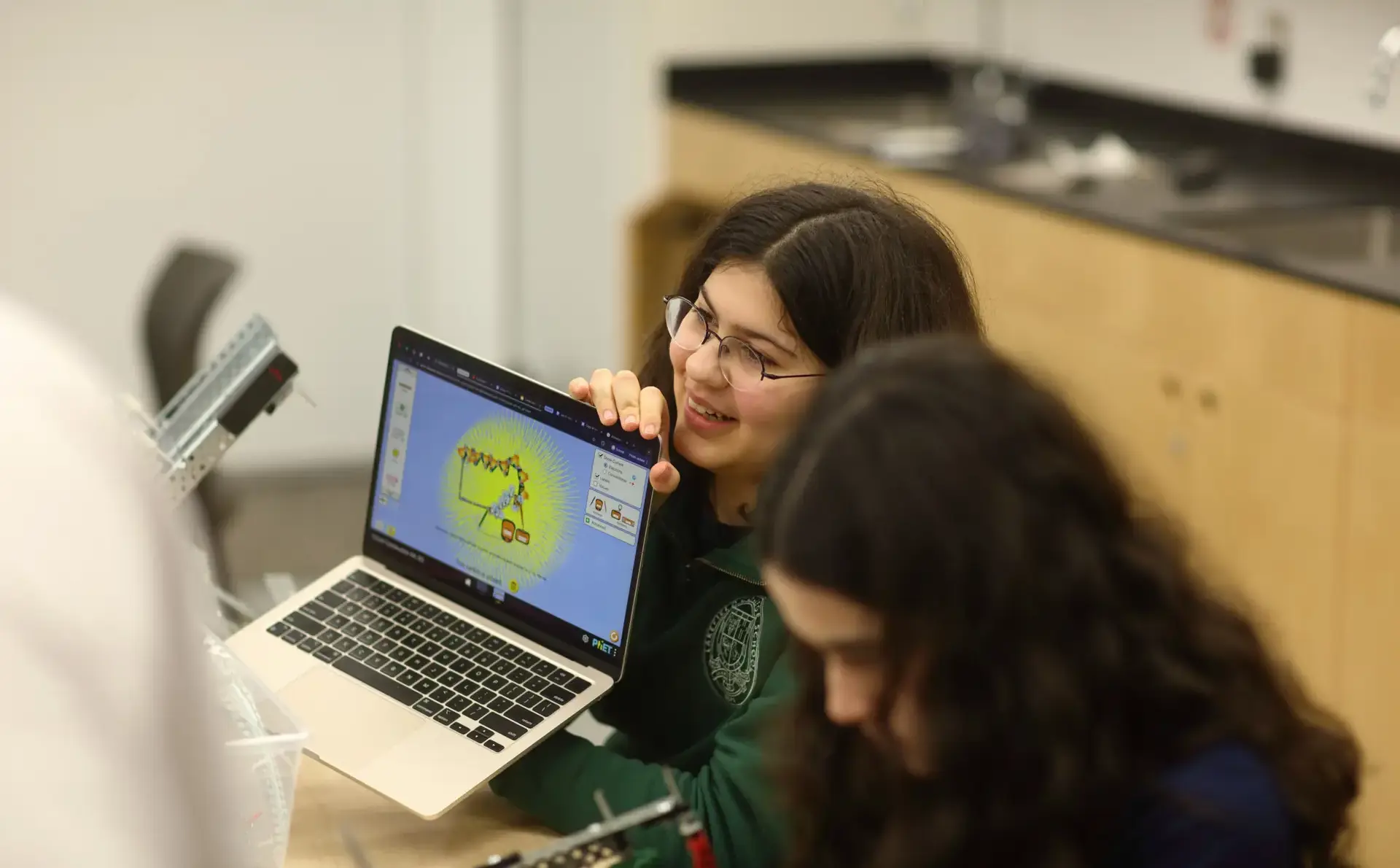 Student showing laptop to classmate