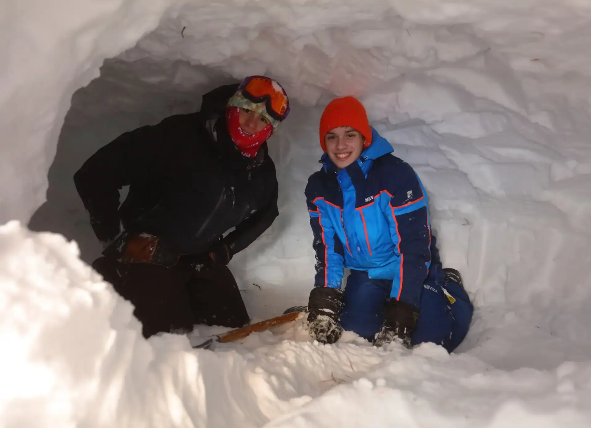 Two students sitting in snow tunnel