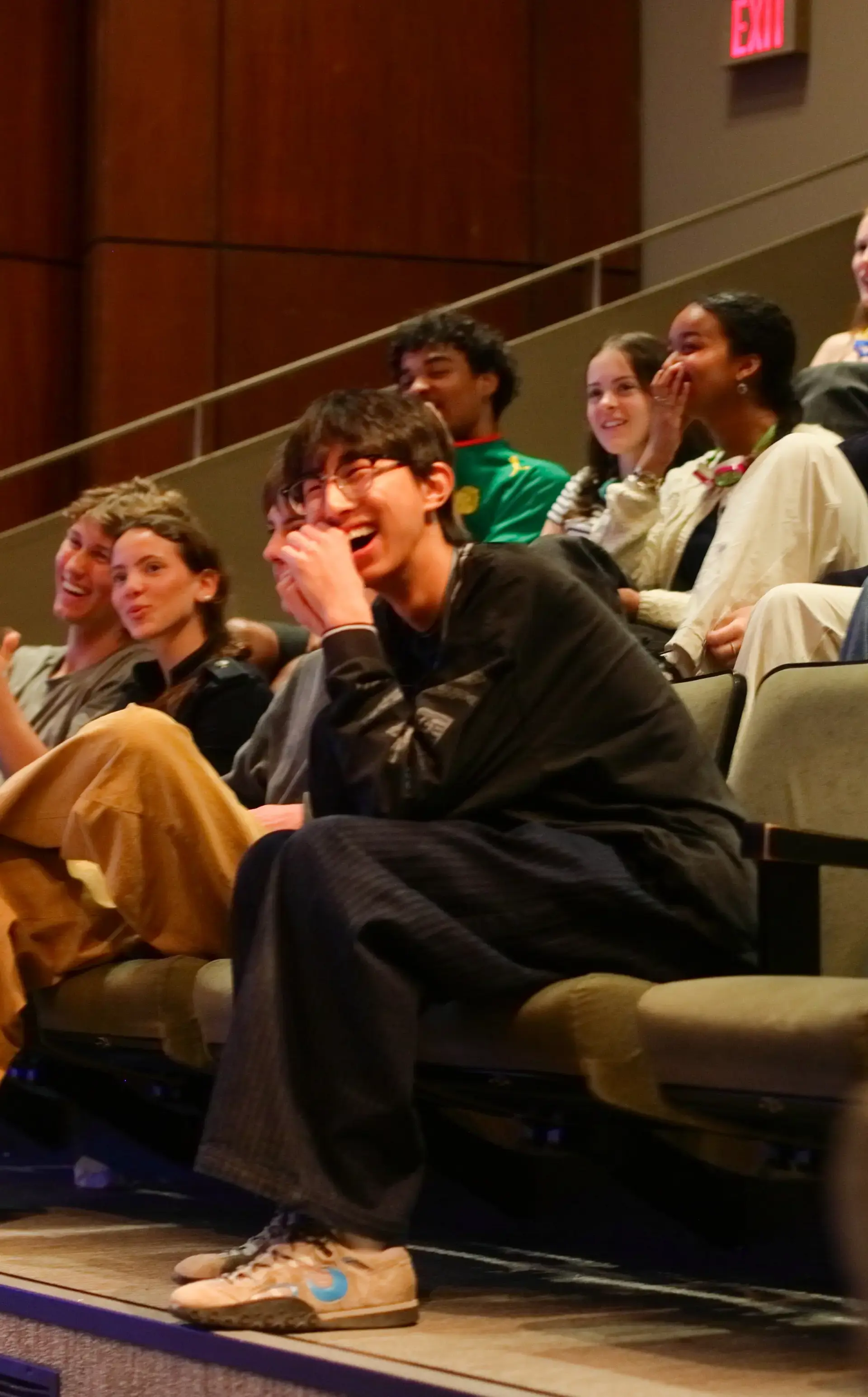 Group of students during intersession watching a performance in the theatre with joy and laughter