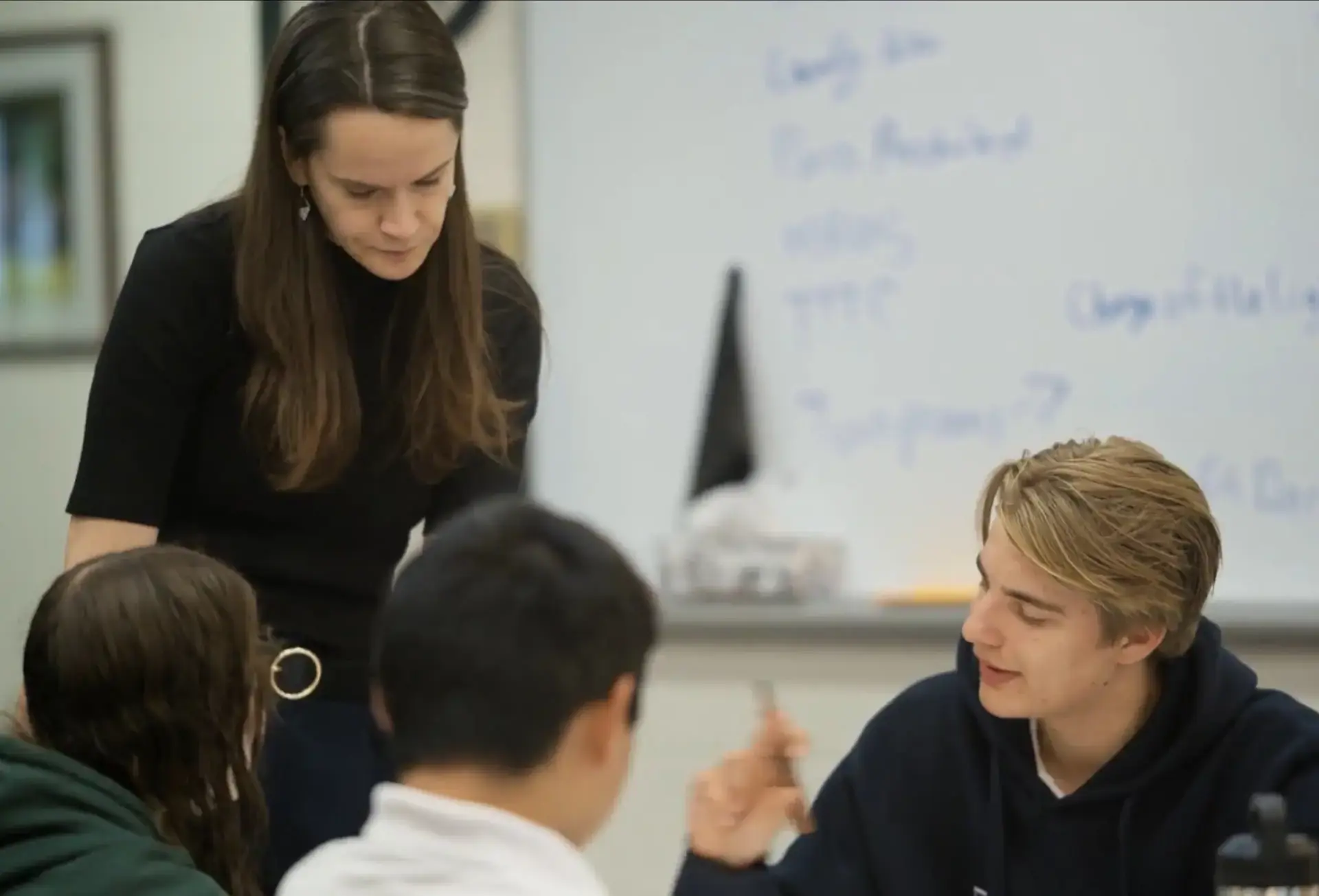 Teacher listening to student discussion