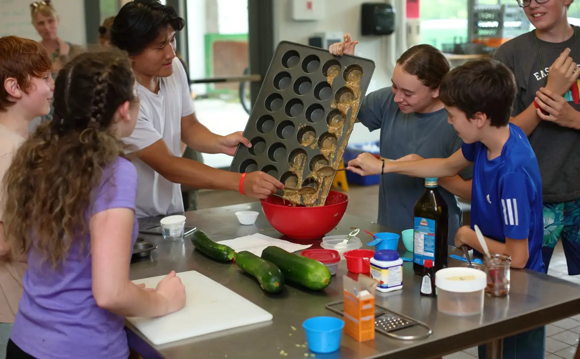 Students pouring batter from baking tray