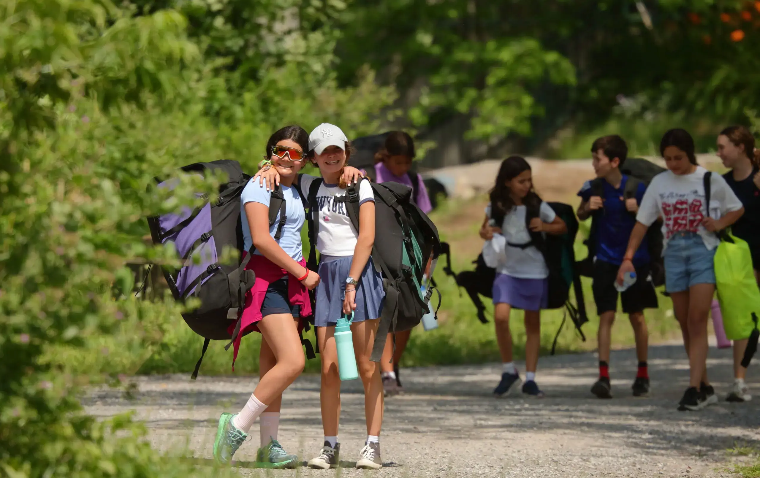 Two students smiling in forested area
