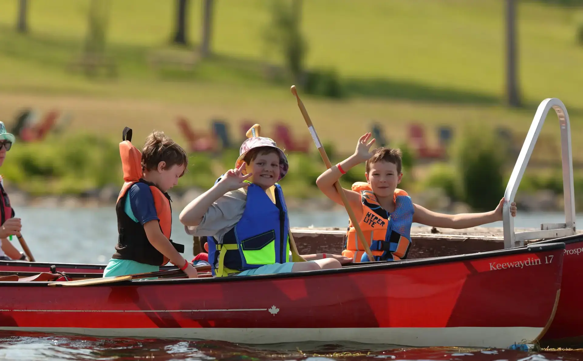 Students waving from boats