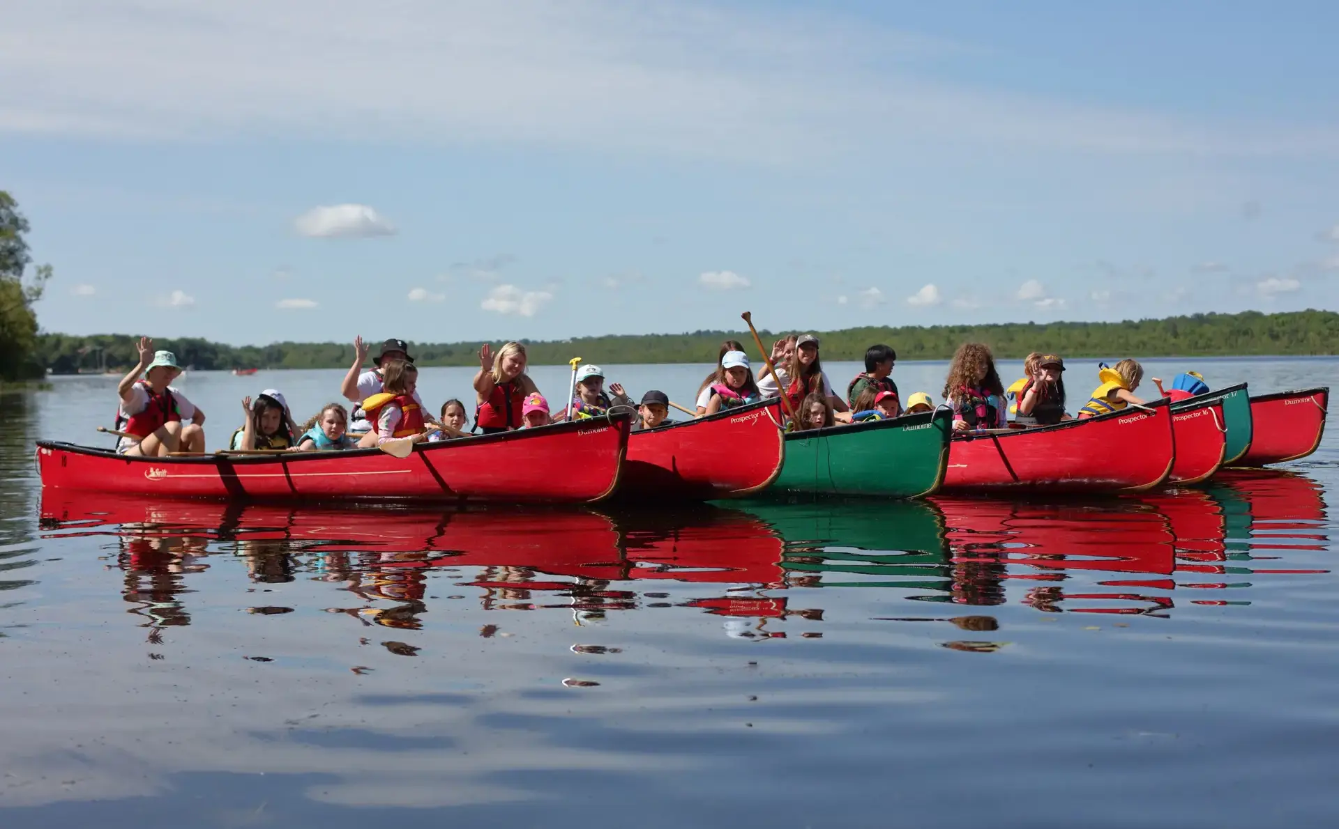 Campers sitting in canoes on calm water