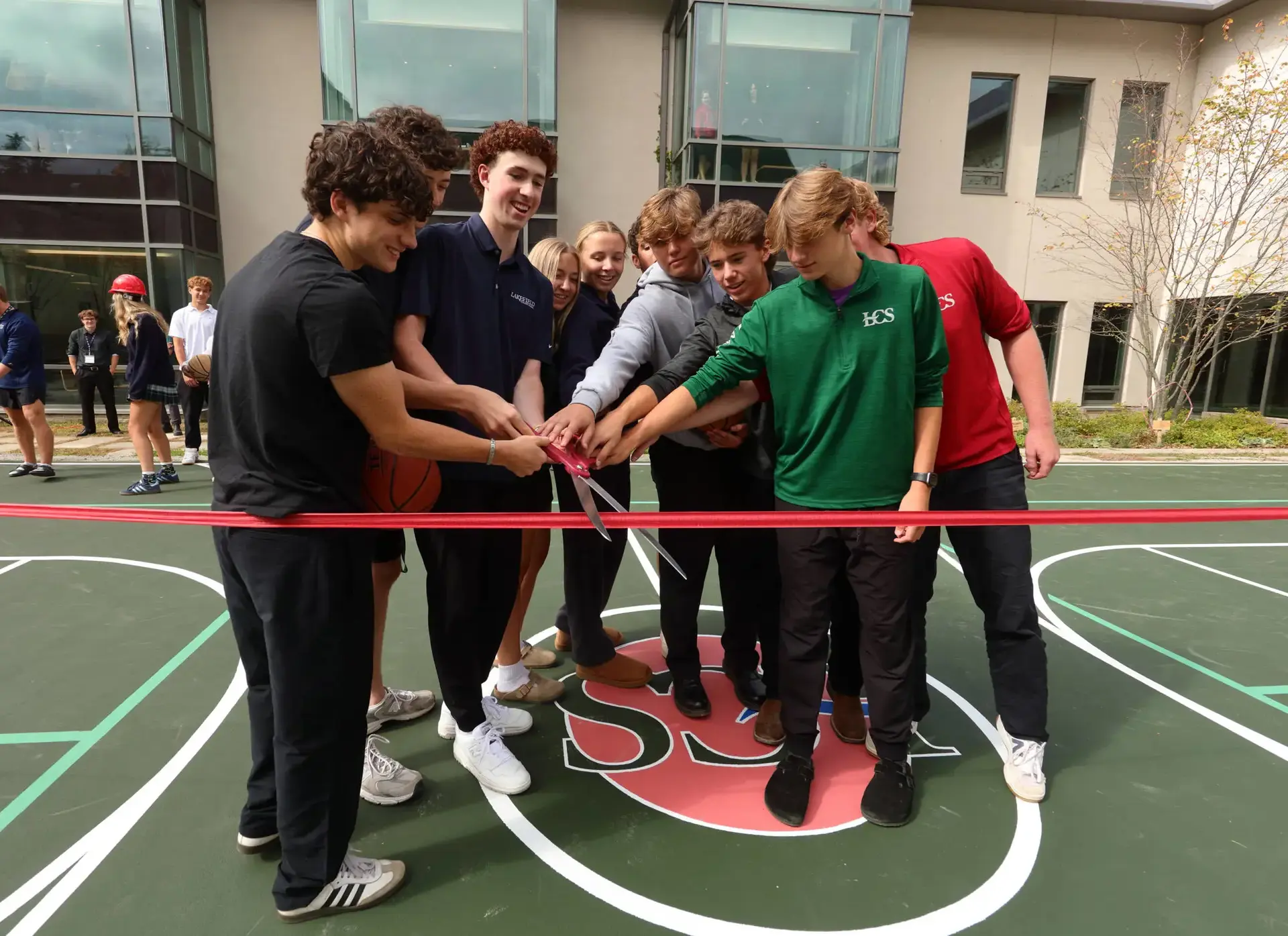 Students cutting ribbon on basketball court