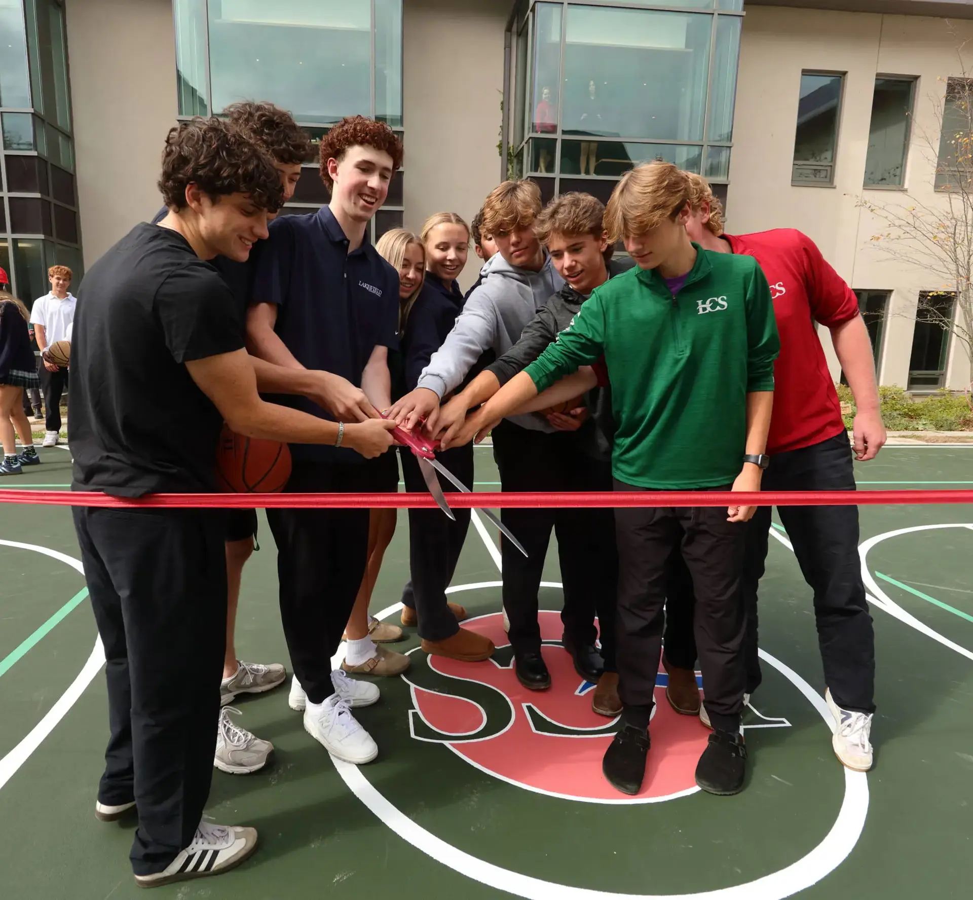 Students cutting ribbon on basketball court