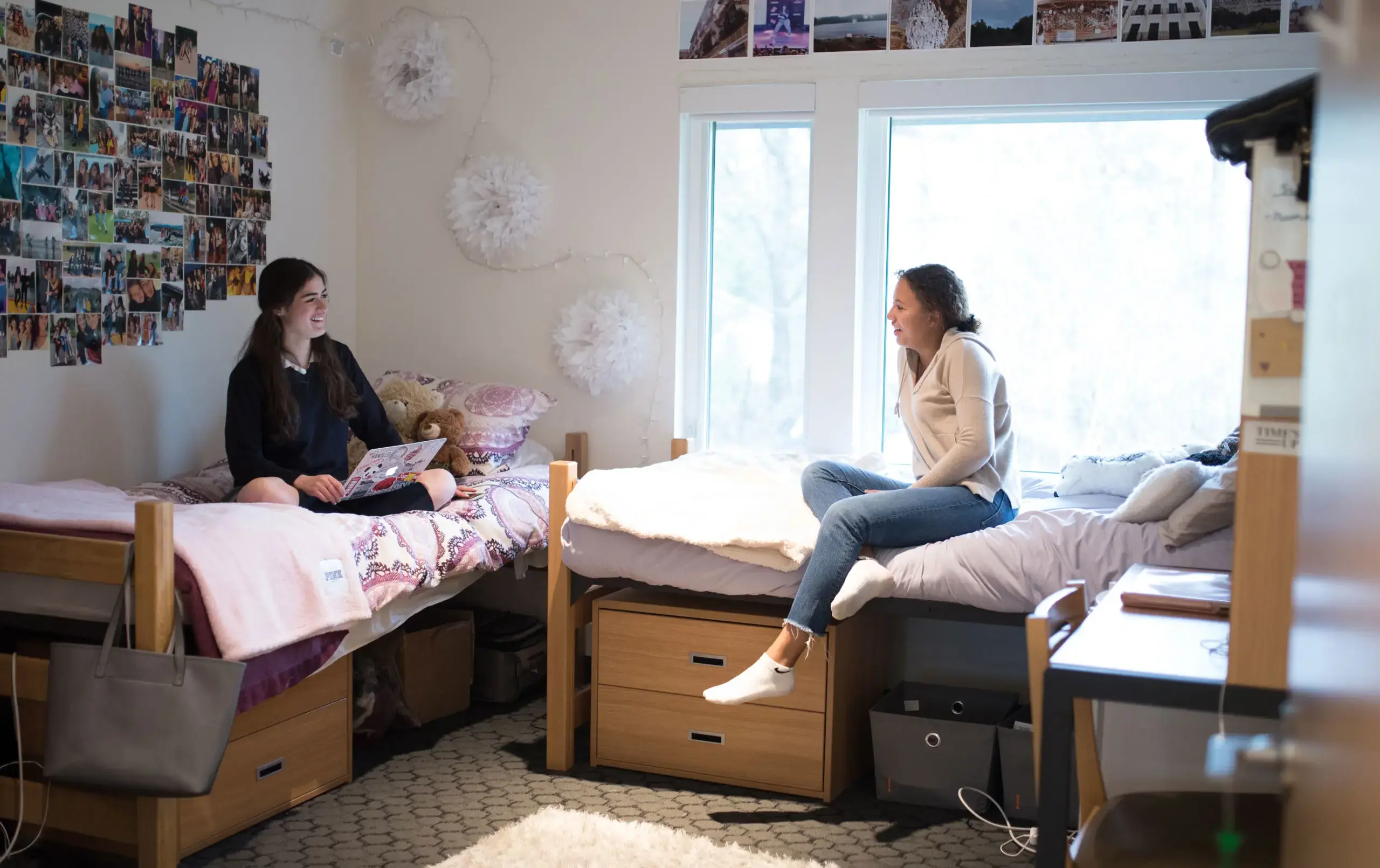 Two students sitting on separate bunks in dorm room