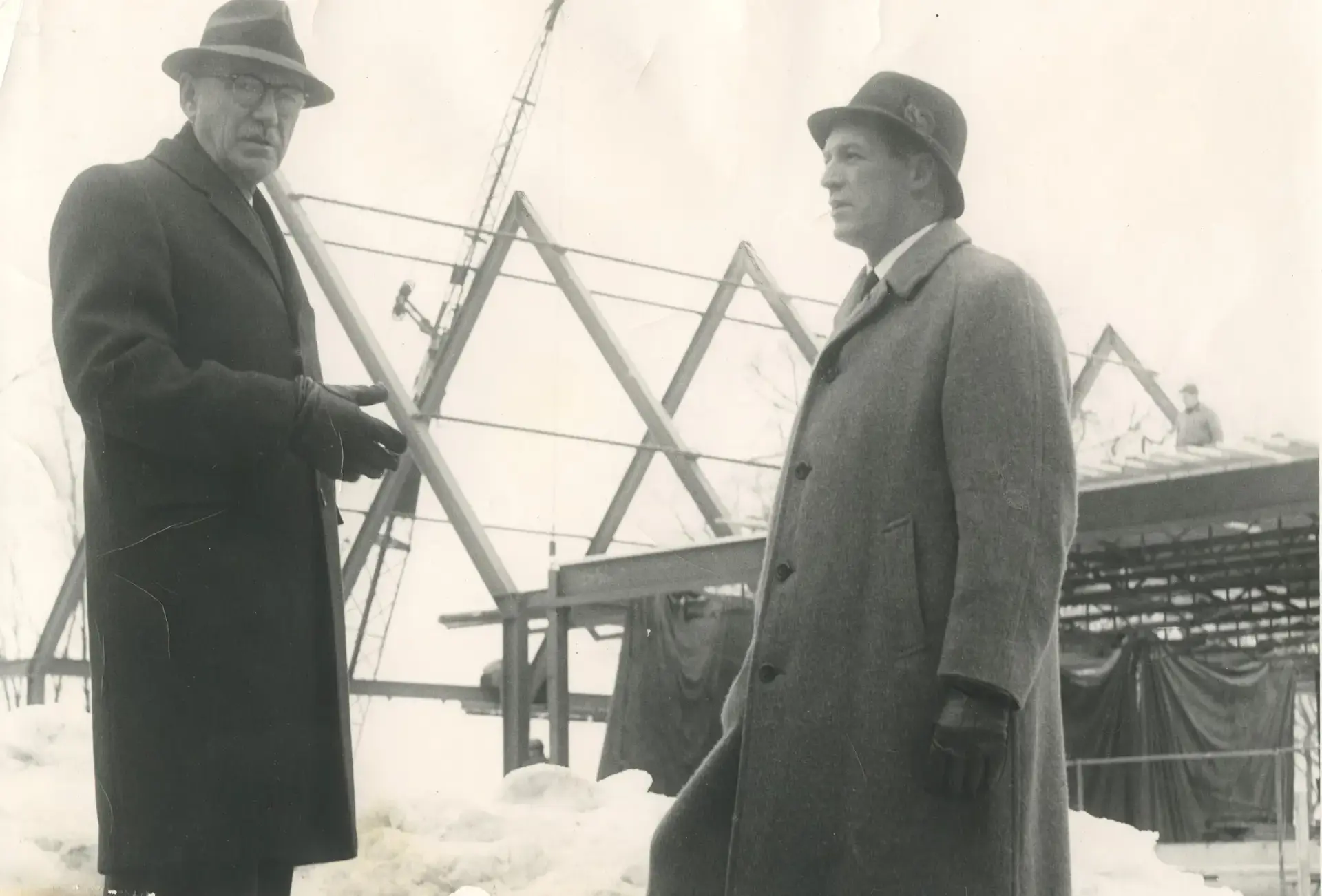 Archival photograph of two men speaking at construction site