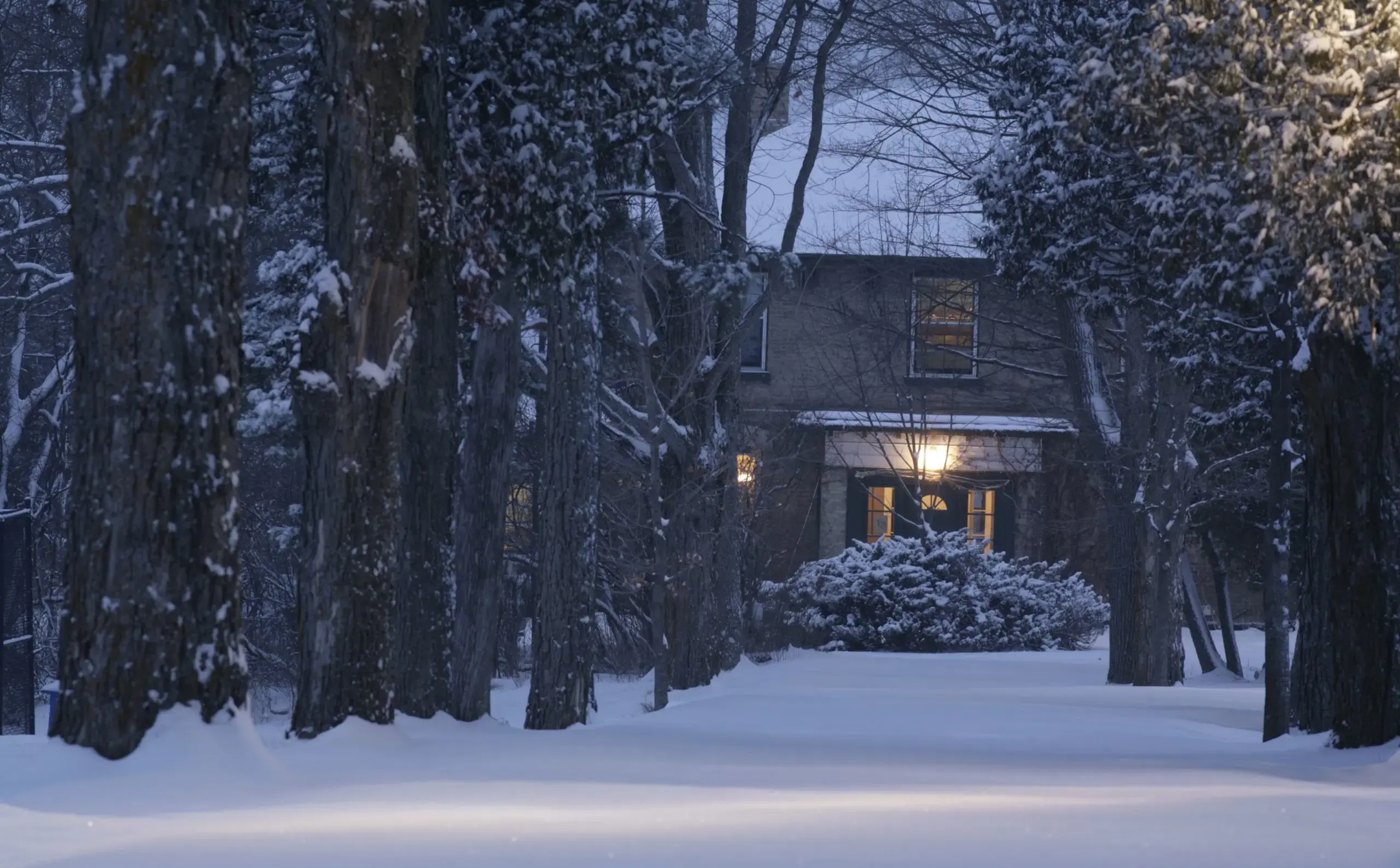 Exterior shot of Ondaatje House, lit up on a wintry night