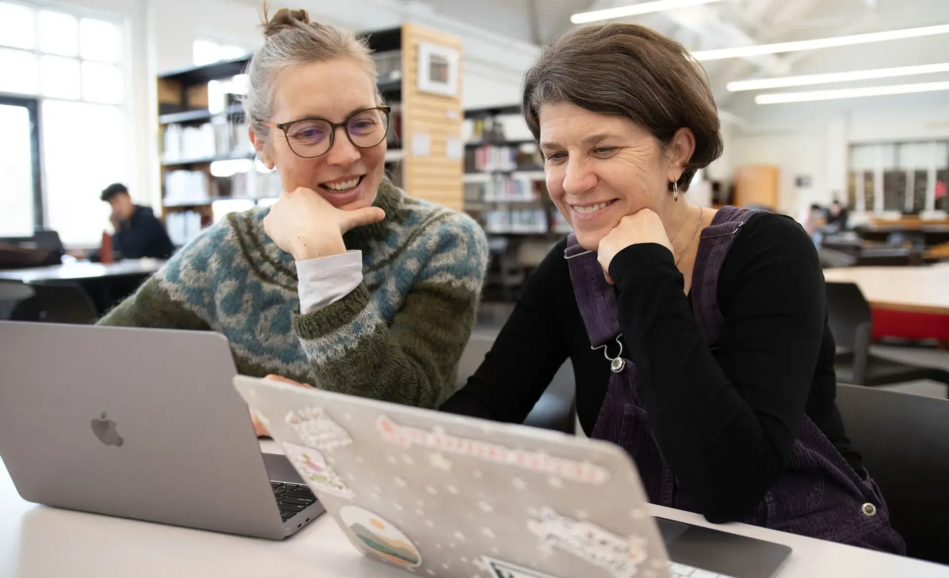 Two staff members looking at laptops