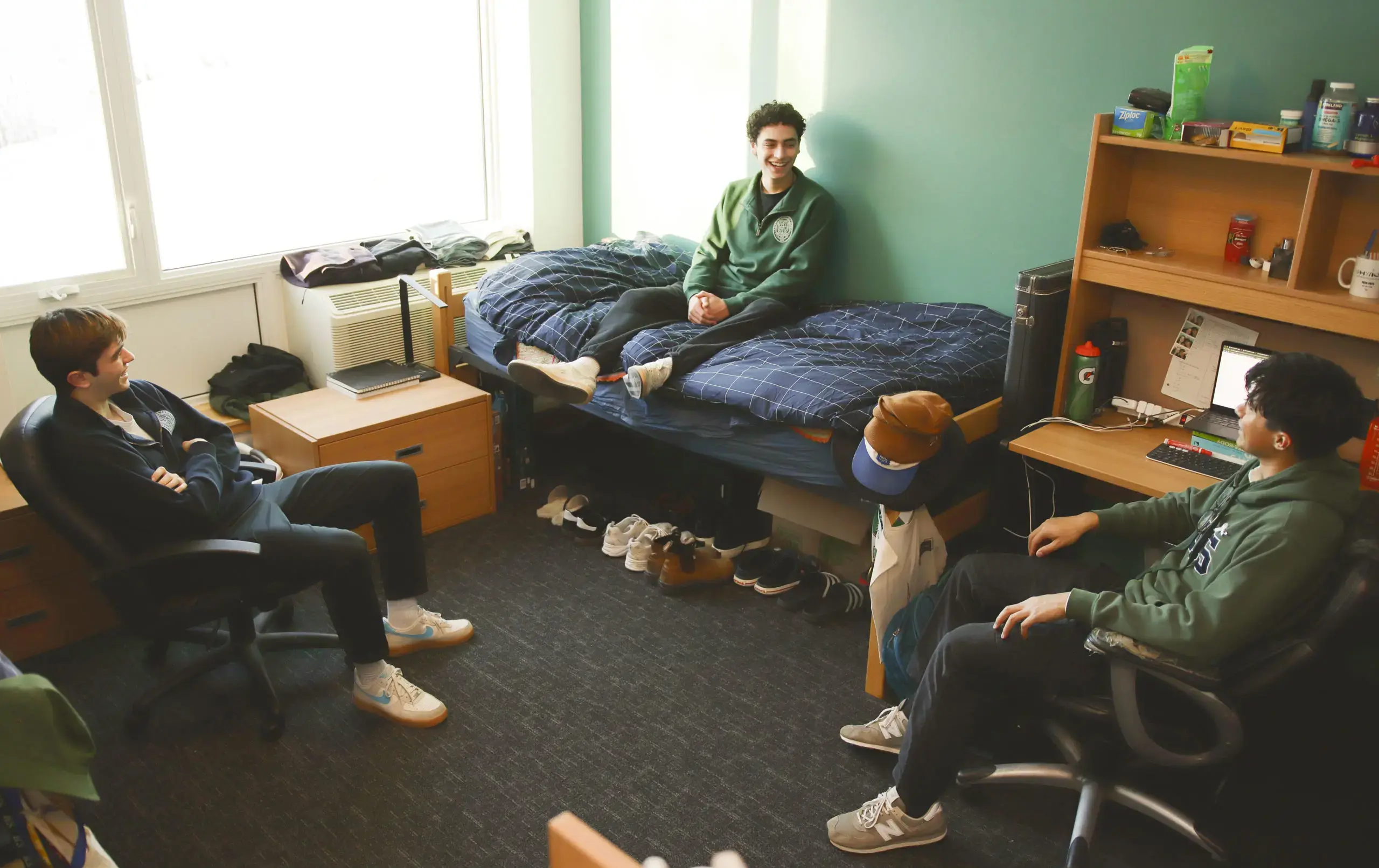 Three students relaxing in dorm room